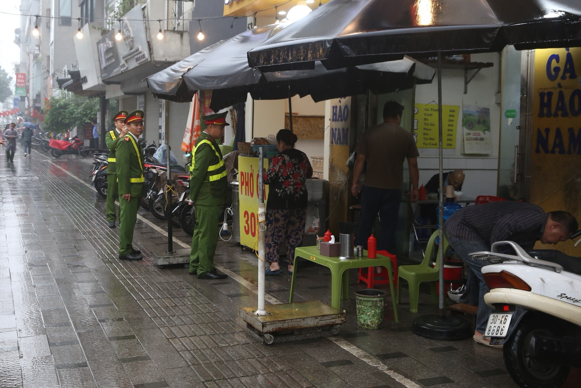 Cán bộ Hà Nội 'đội mưa' đi lấy lại vỉa hè cho người đi bộ - Ảnh 1.