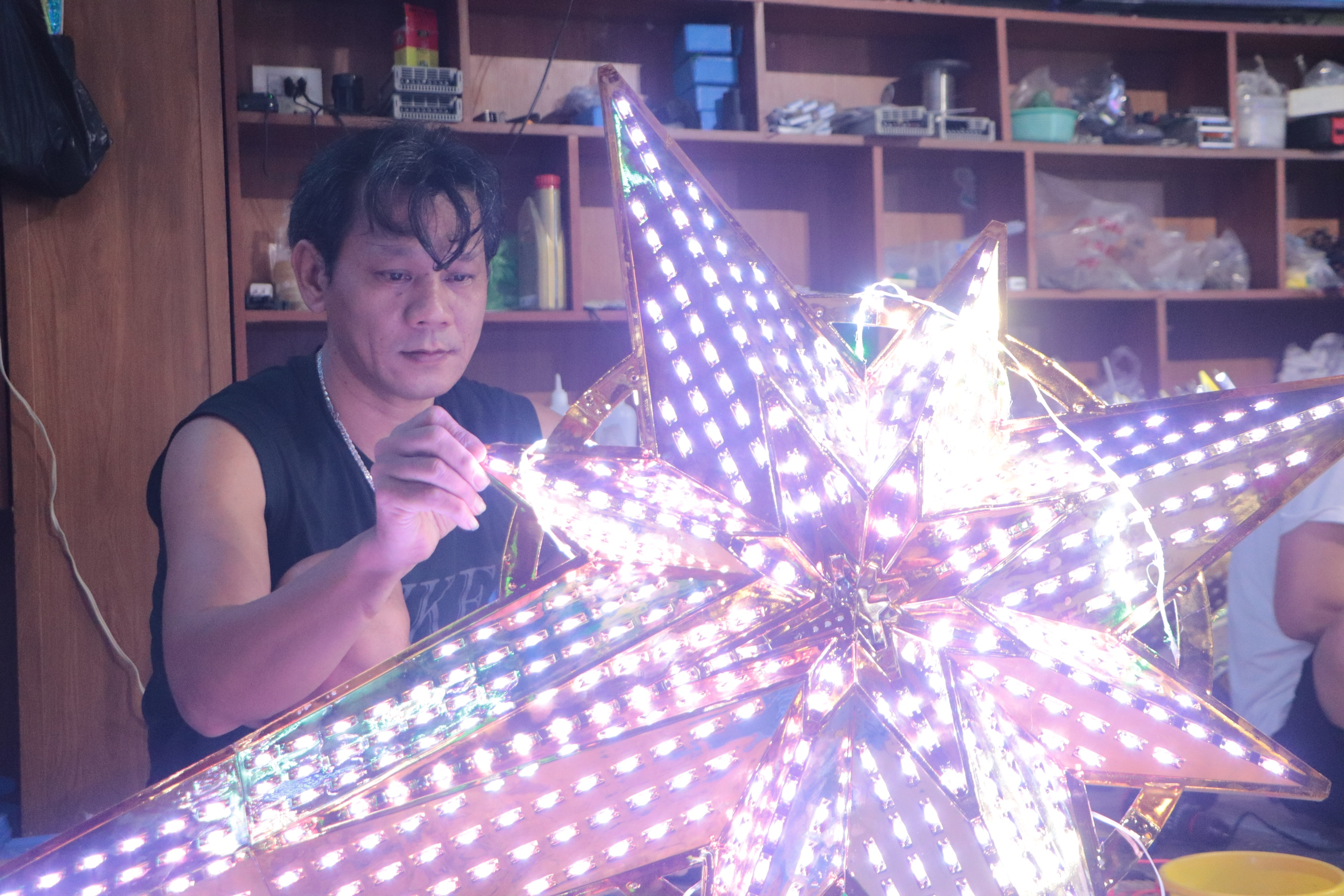 Tampilan jarak dekat dari bengkel yang membuat bintang LED untuk Katedral Notre Dame - Foto 2.