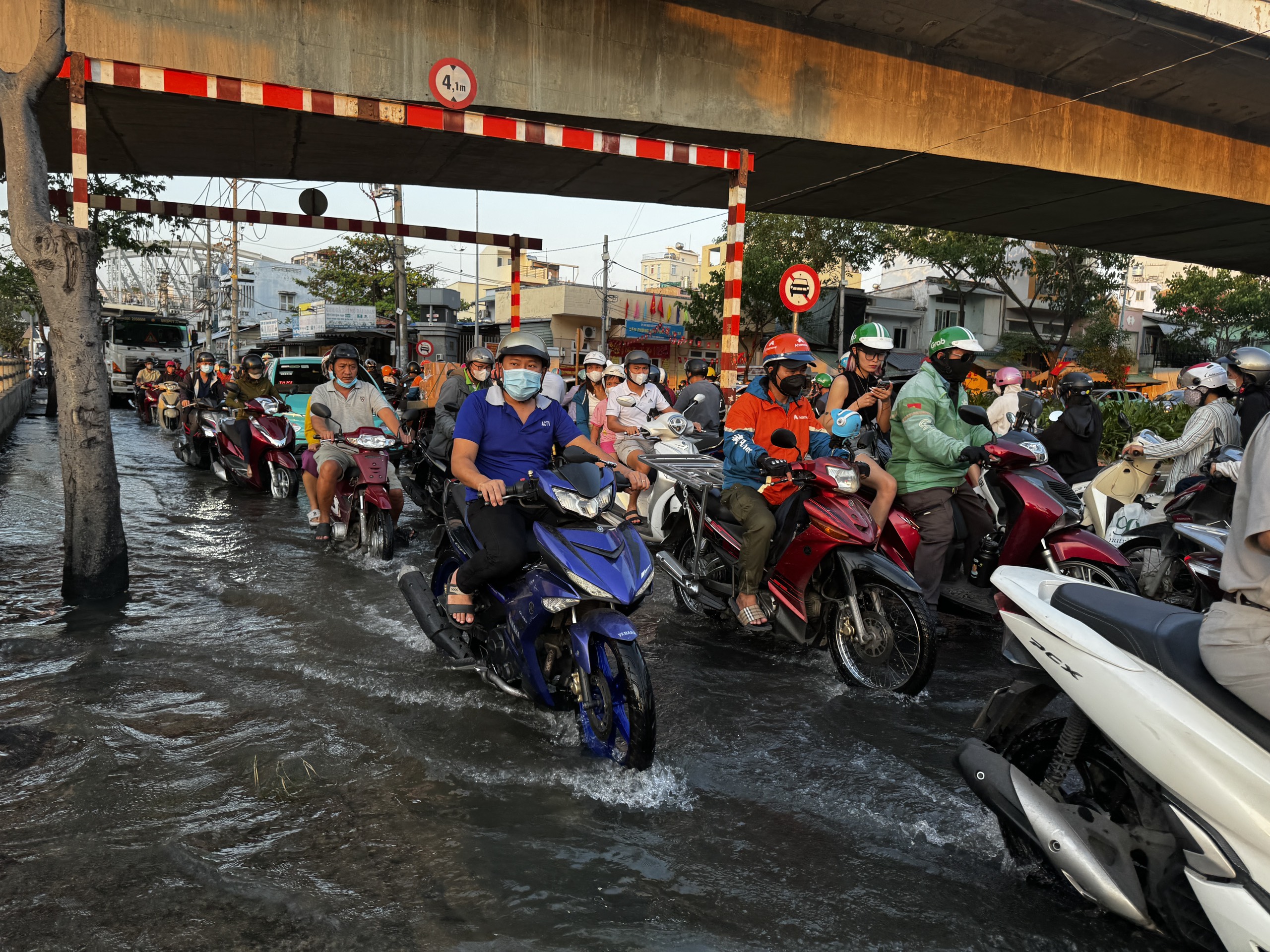 Chiều tối triều cường dâng ở TP.HCM, người dân vất vả lội nước giờ tan tầm - Ảnh 1.