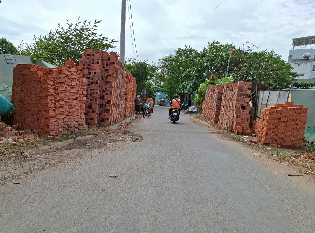Vật liệu xây dựng chất cao bên đường, nguy hiểm- Ảnh 1.
