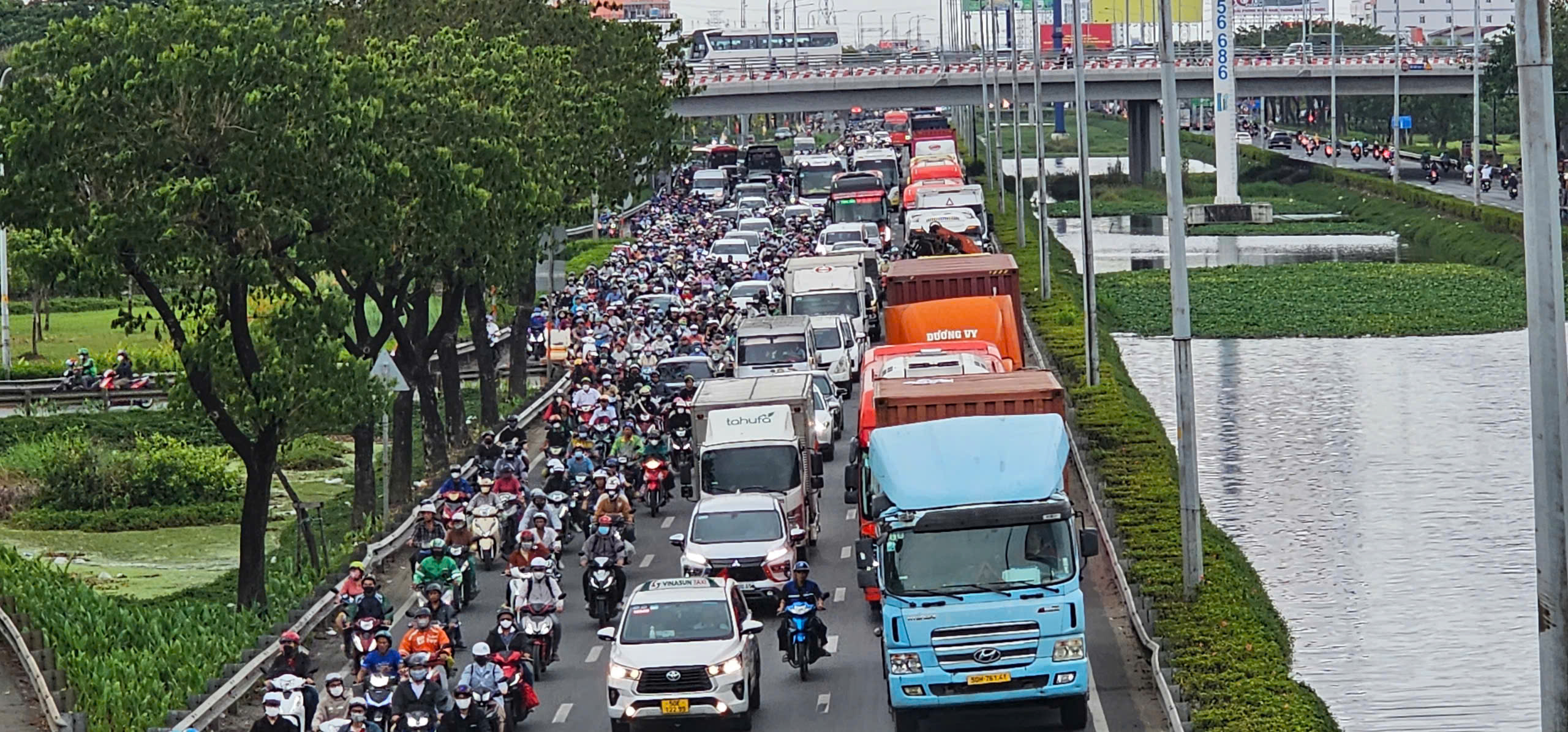Cửa ngõ phía tây TP.HCM chật kín người, bãi xe quá tải - Ảnh 1.