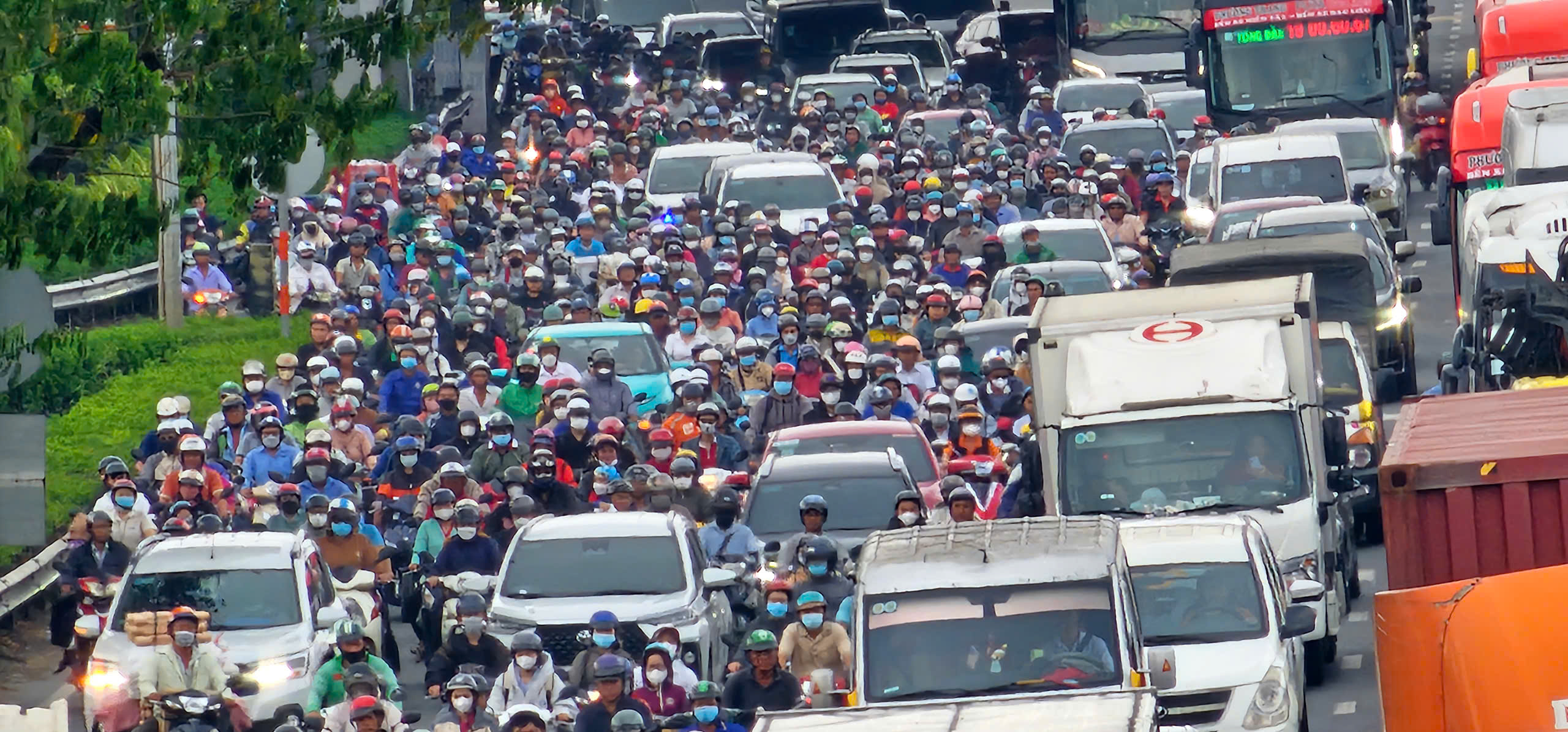 Cửa ngõ phía tây TP.HCM chật kín người, bãi xe quá tải - Ảnh 2.
