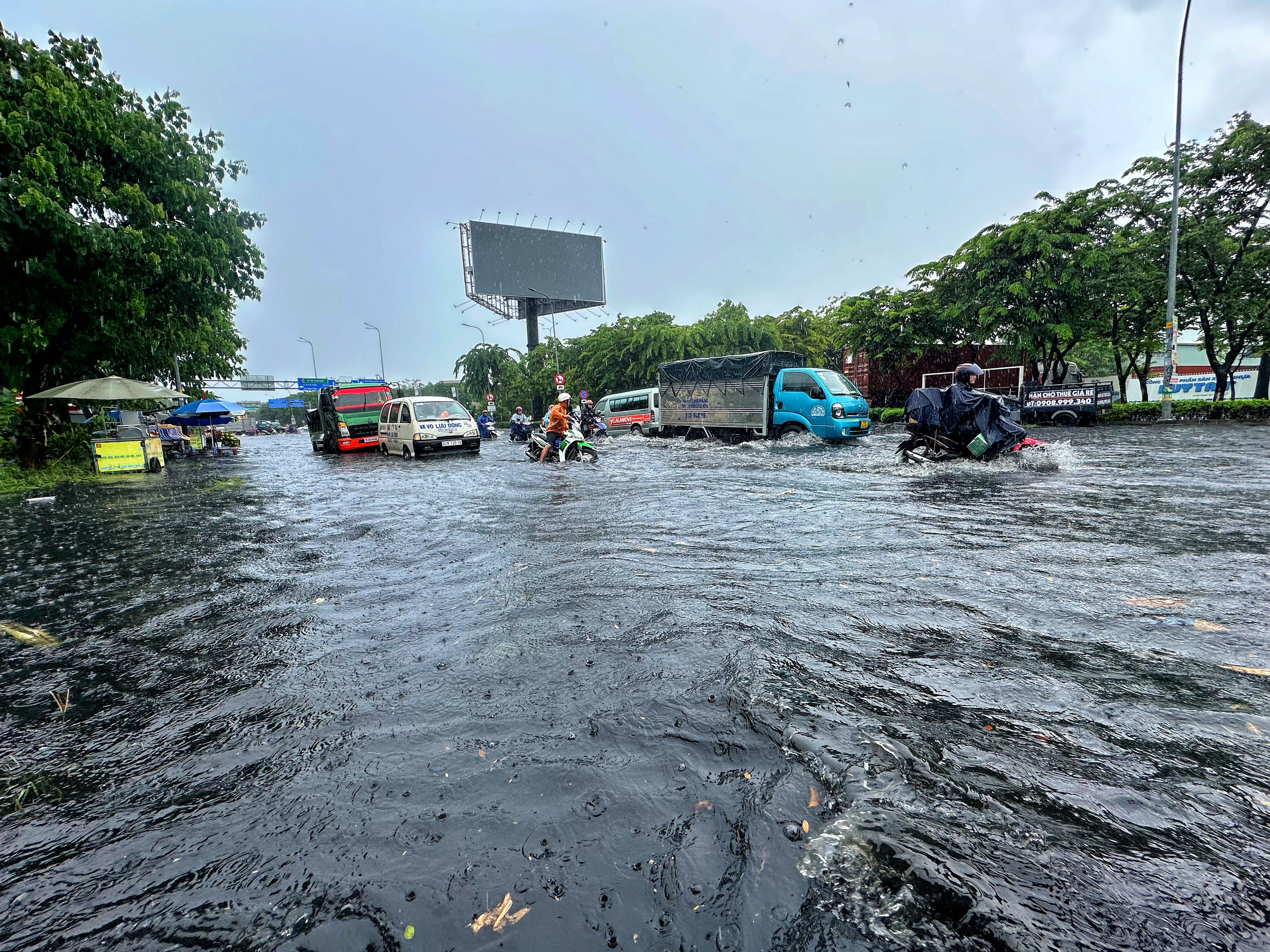 TP.HCM có mưa lớn xối xả giữa trưa: Đường ngập, người dân 'vật lộn' giữa biển nước - Ảnh 2.