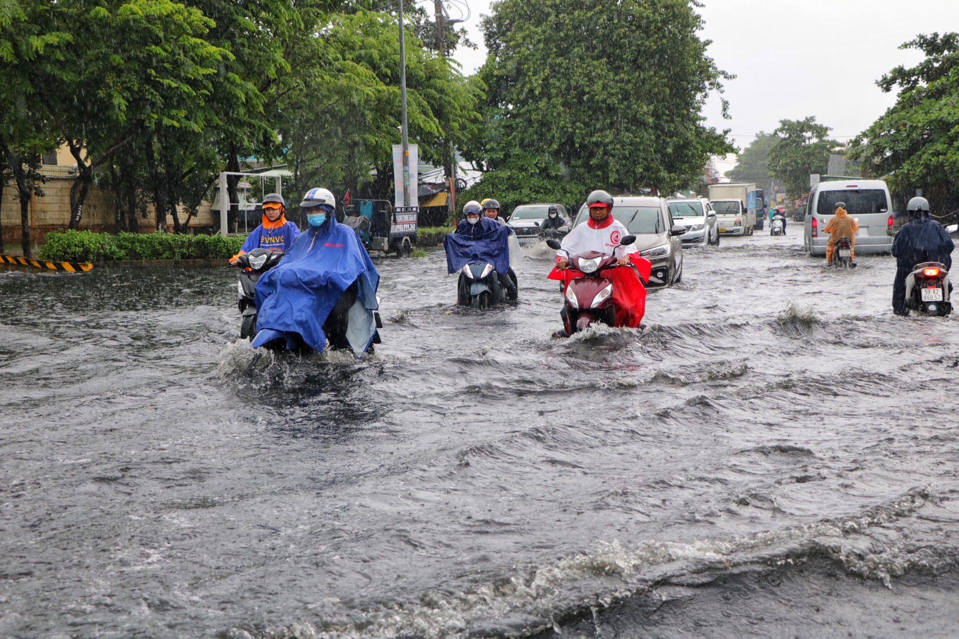TP.HCM có mưa lớn xối xả giữa trưa: Đường ngập, người dân 'vật lộn' giữa biển nước - Ảnh 3.