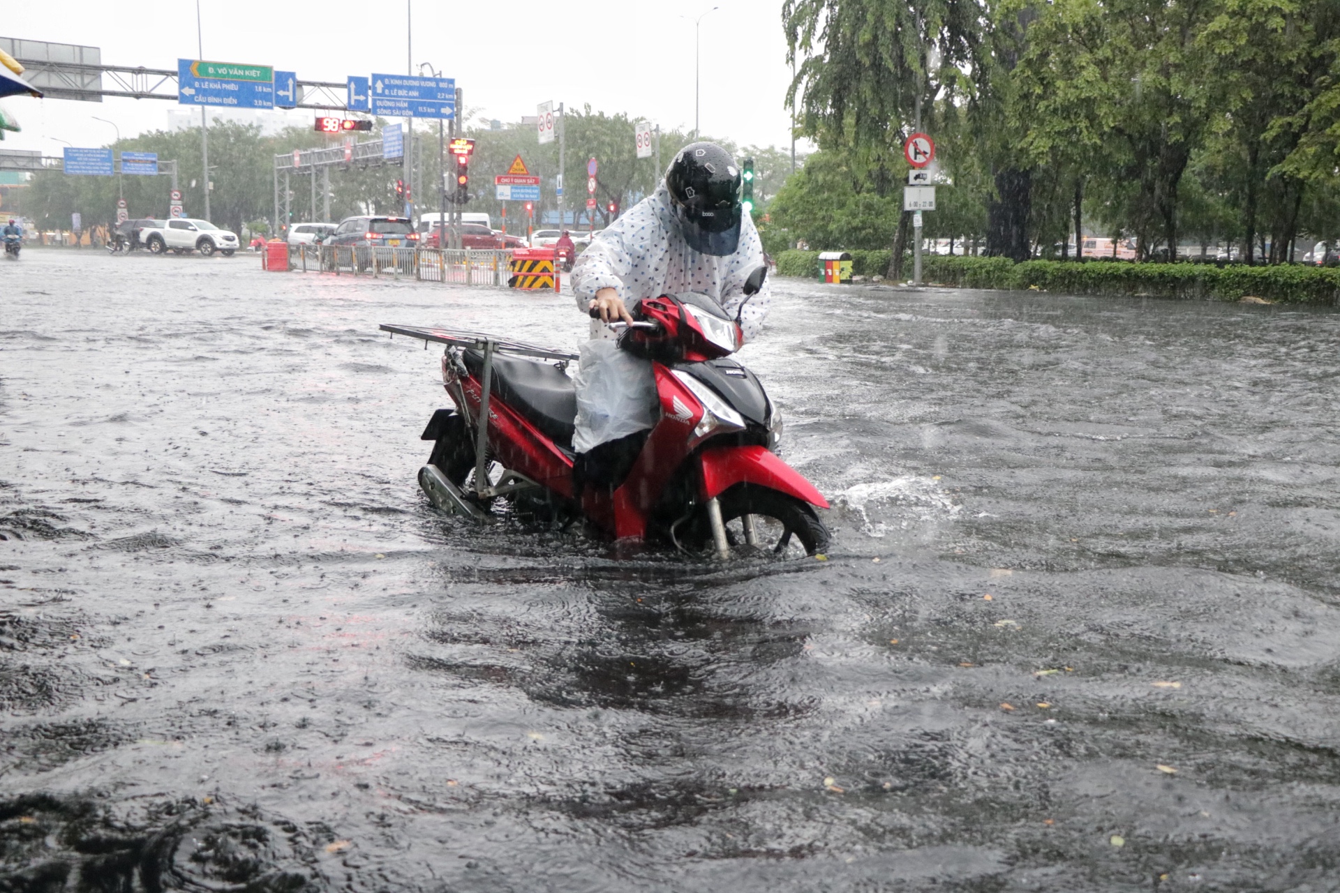 TP.HCM có mưa rất to chiều nay: Nước ngập gần hết bánh xe, người dân 'vượt sóng'- Ảnh 9.
