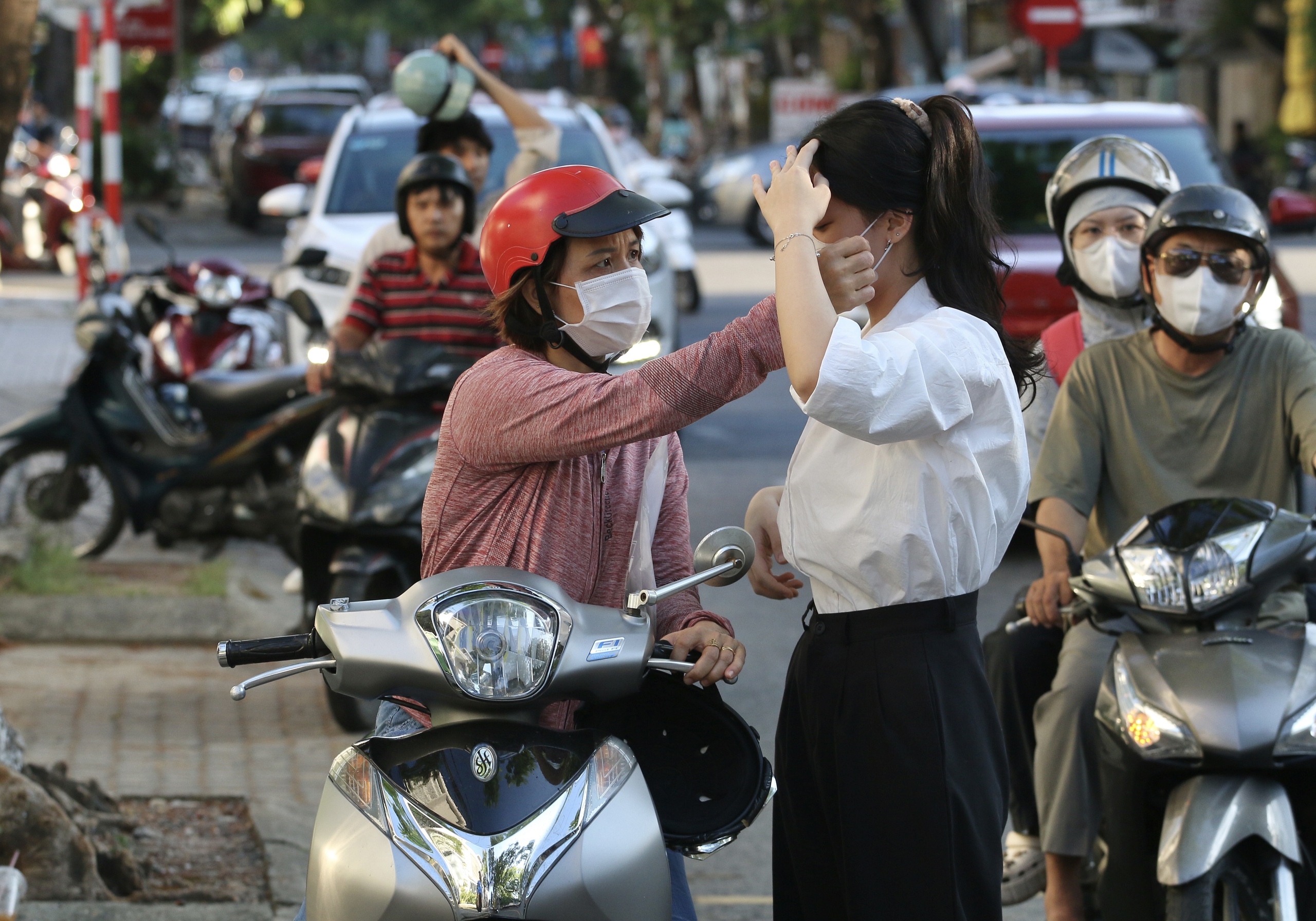 Phụ huynh 'đứng ngồi không yên' ở vỉa hè chờ con thi tốt nghiệp THPT- Ảnh 1.