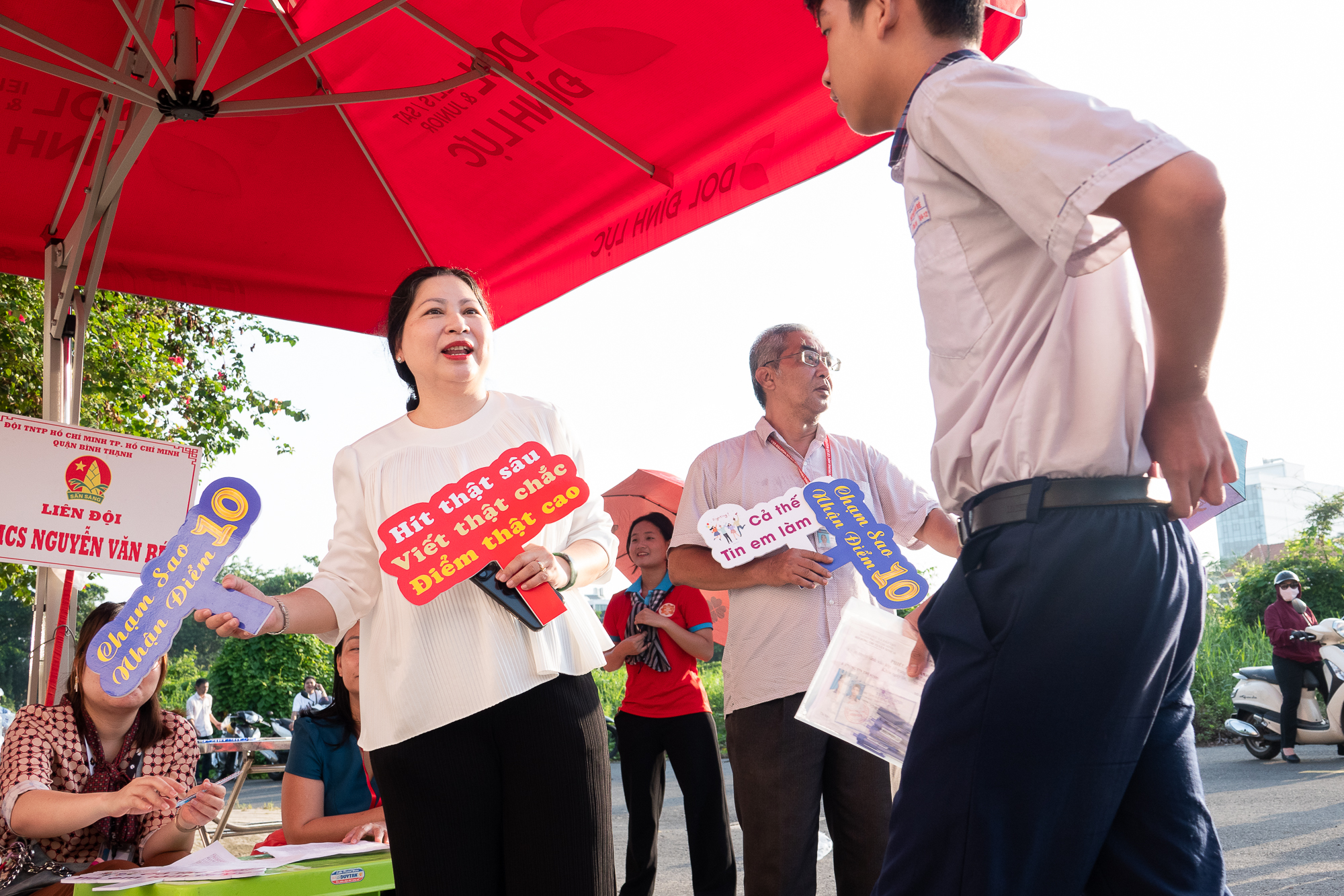 Lehrer in Ho-Chi-Minh-Stadt tragen Schuluniformen und halten Schilder mit der Aufschrift „Die ganze Welt glaubt, dass du es schaffen kannst!“ hoch. - Foto 2. Thầy cô TP.HCM mặc áo lớp, cầm biển cổ vũ, 'Cả thế giới tin em làm được'!- Ảnh 2.