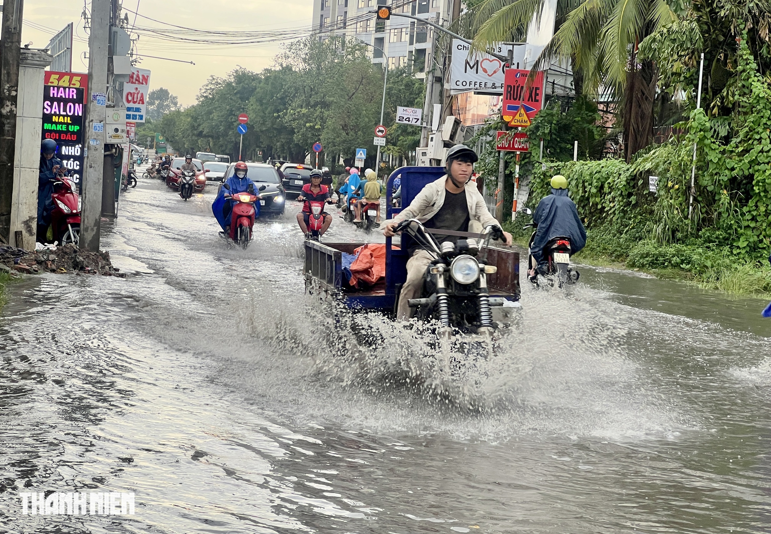 Mưa lớn gây ngập ngay chân cầu ở TP.HCM: Rẽ sóng vượt qua - Ảnh 2.