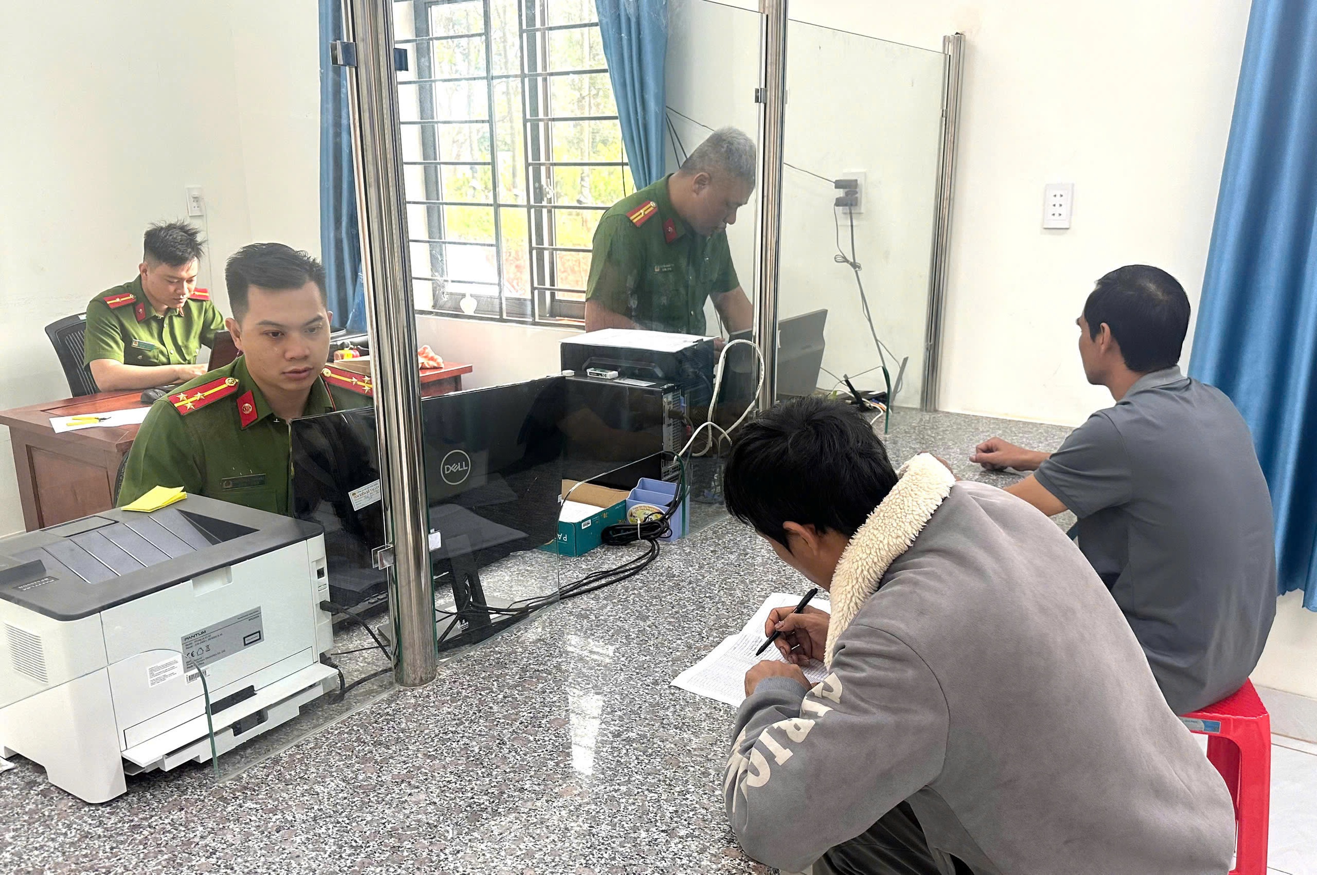 Công an xã hỗ trợ người dân làm thủ tục hành chính- Ảnh 1.