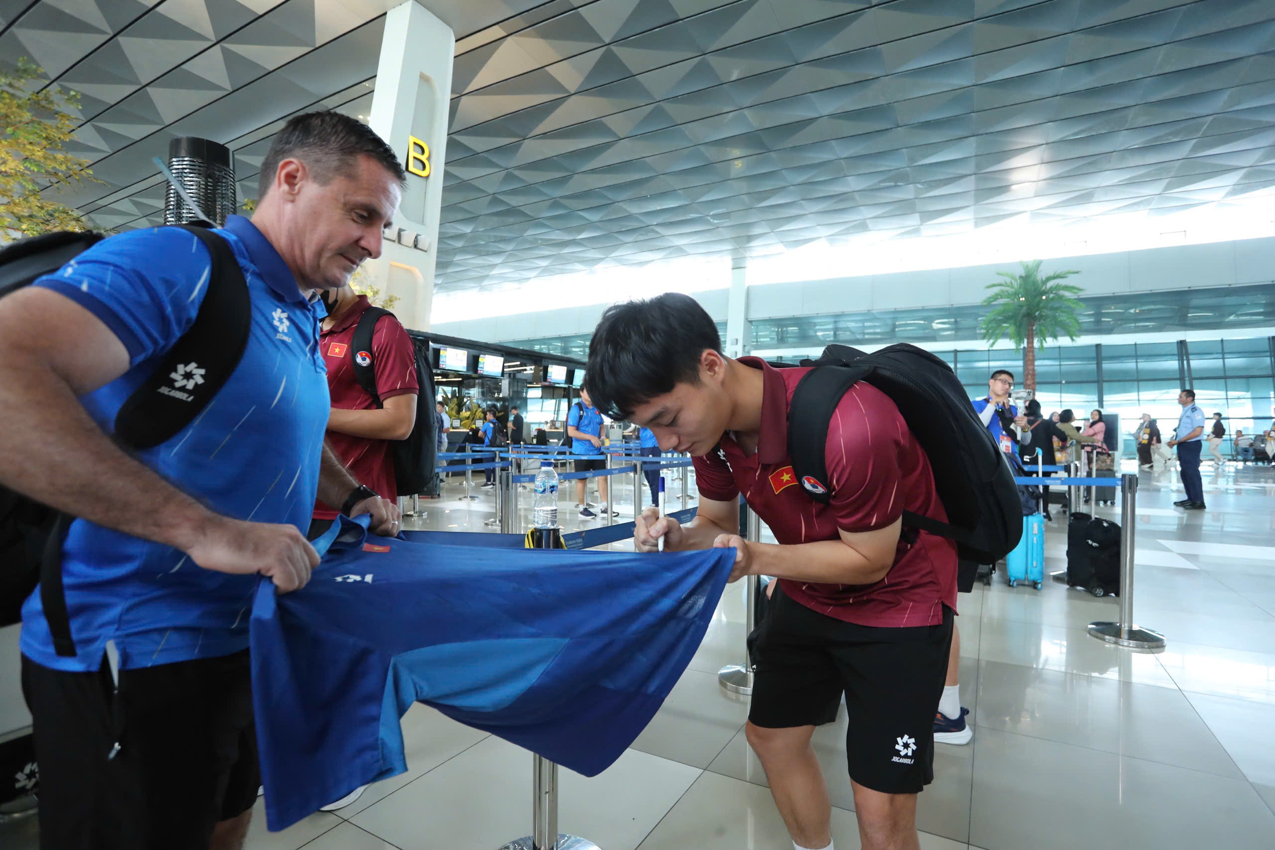 Dinh Bac “តស៊ូ” ដើម្បីដណ្ដើមពានរង្វាន់ អ្នកគាំទ្រឥណ្ឌូណេស៊ីបានសុំប័ណ្ណ U.23 វៀតណាមនៅព្រលានយន្តហោះ - រូបថត ៨. Đình Bắc ‘khệ nệ’ cầm cúp, CĐV Indonesia xin chữ ký U.23 Việt Nam ở sân bay- Ảnh 8.