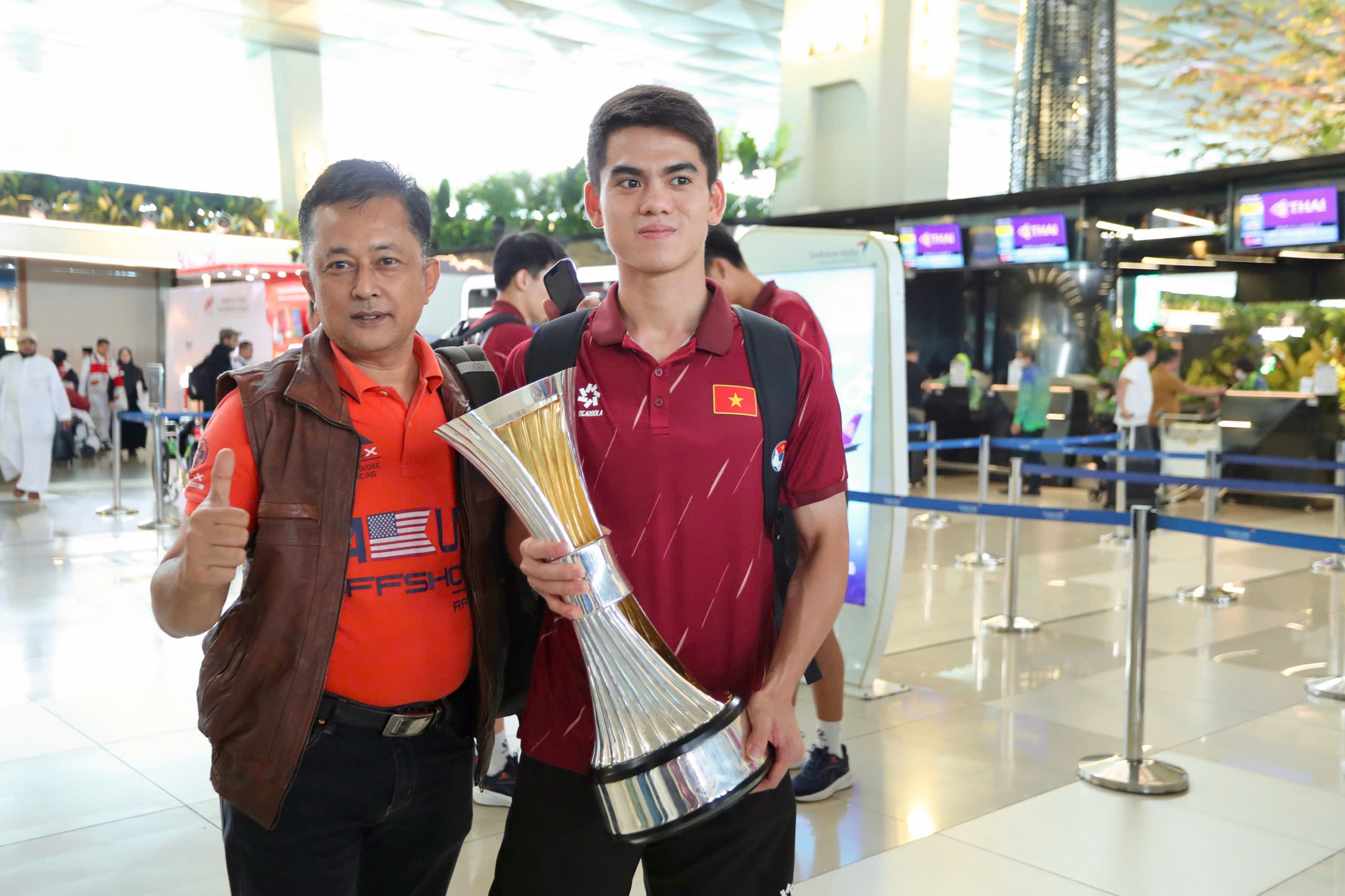 Dinh Bac “តស៊ូ” ដើម្បីដណ្ដើមពានរង្វាន់ អ្នកគាំទ្រឥណ្ឌូណេស៊ីបានសុំប័ណ្ណ U.23 វៀតណាមនៅព្រលានយន្តហោះ - រូបថត ១០. Đình Bắc ‘khệ nệ’ cầm cúp, CĐV Indonesia xin chữ ký U.23 Việt Nam ở sân bay- Ảnh 10.