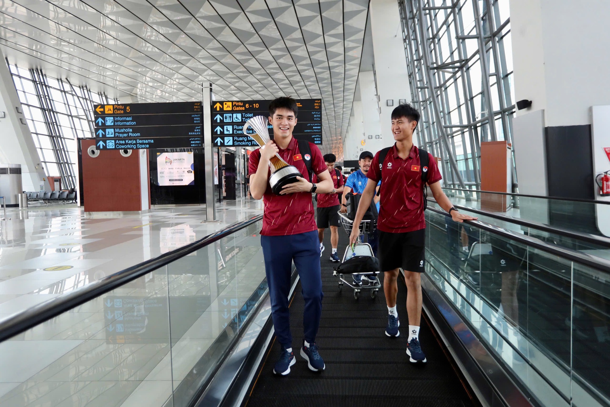 Dinh Bac “តស៊ូ” ដើម្បីដណ្ដើមពានរង្វាន់ អ្នកគាំទ្រឥណ្ឌូណេស៊ីបានសុំប័ណ្ណ U.23 វៀតណាមនៅព្រលានយន្តហោះ - រូបថត ៣. Đình Bắc ‘khệ nệ’ cầm cúp, CĐV Indonesia xin chữ ký U.23 Việt Nam ở sân bay- Ảnh 3.