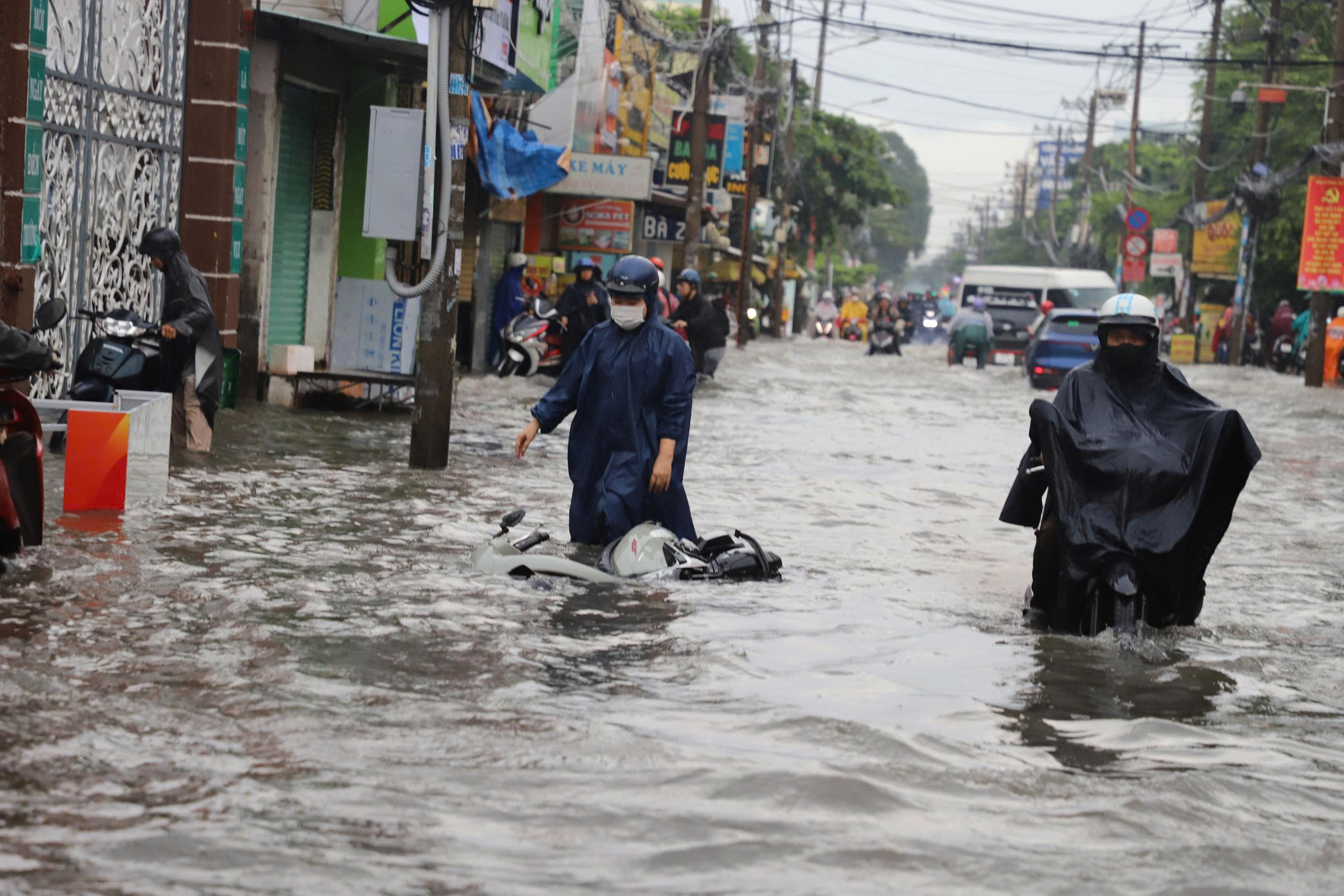 TP.HCM: Ngập sâu, người đi đường 'chôn chân' chờ nước rút - Ảnh 1. TP.HCM: Ngập sâu, người đi đường 'chôn chân' chờ nước rút - Ảnh 1.