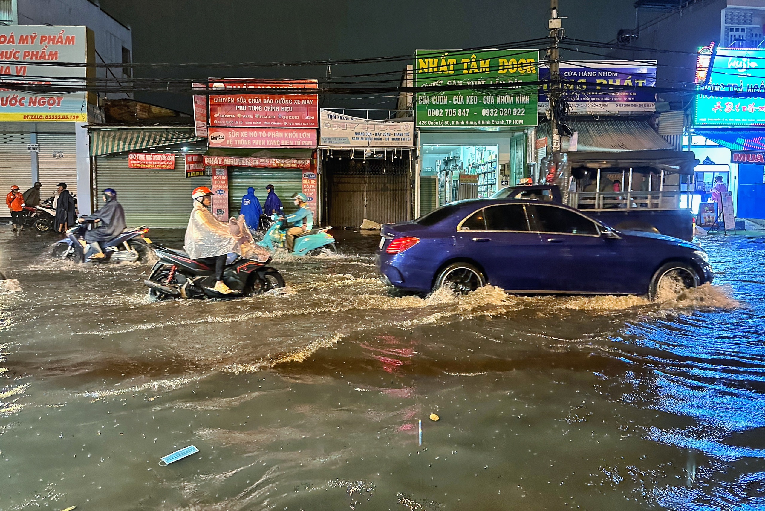 TP.HCM có mưa lớn trong đêm: Người dân chật vật 'vượt sóng' trên Quốc lộ 50 - Ảnh 2.