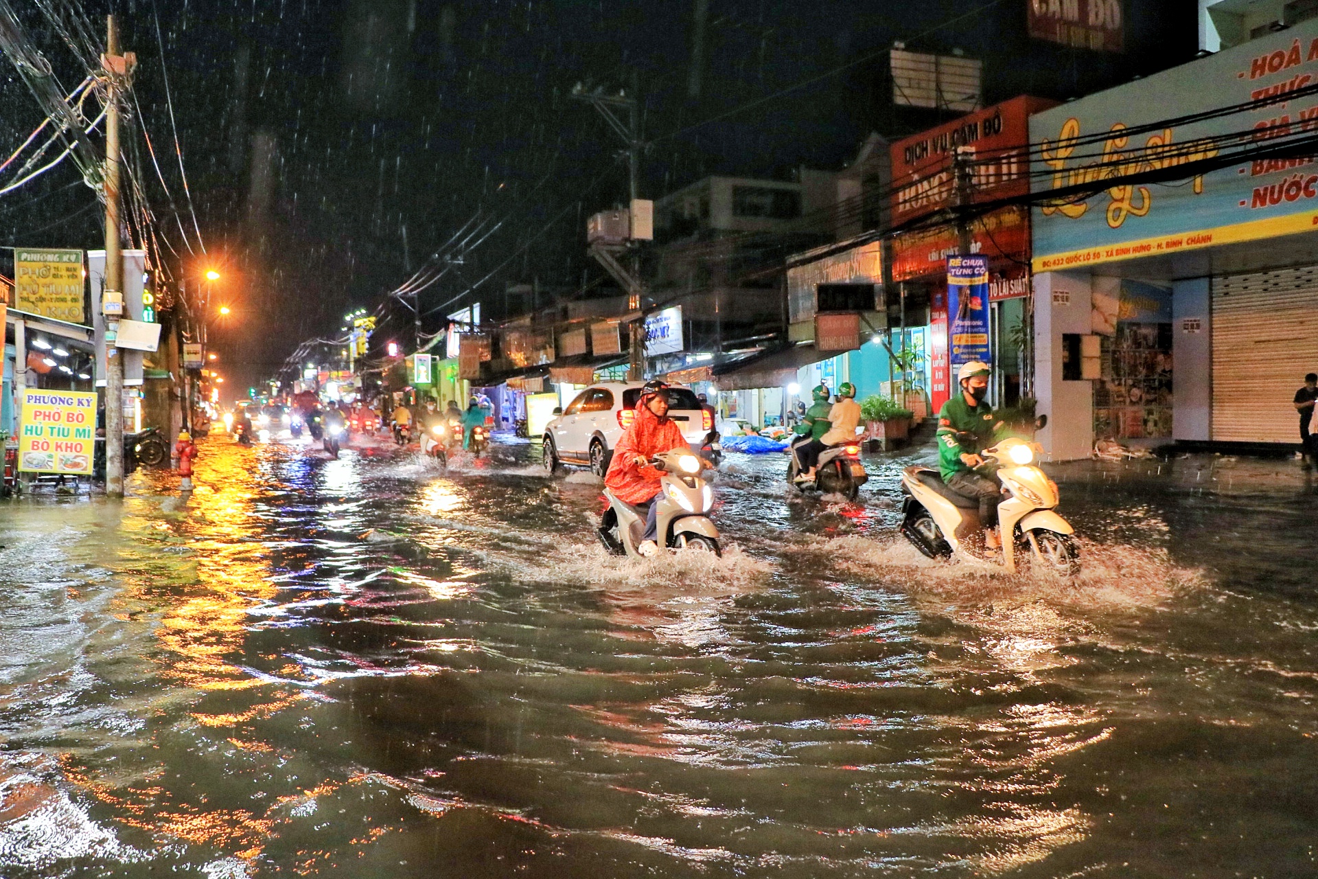 TP.HCM có mưa lớn trong đêm: Người dân chật vật 'vượt sóng' trên Quốc lộ 50 - Ảnh 1.