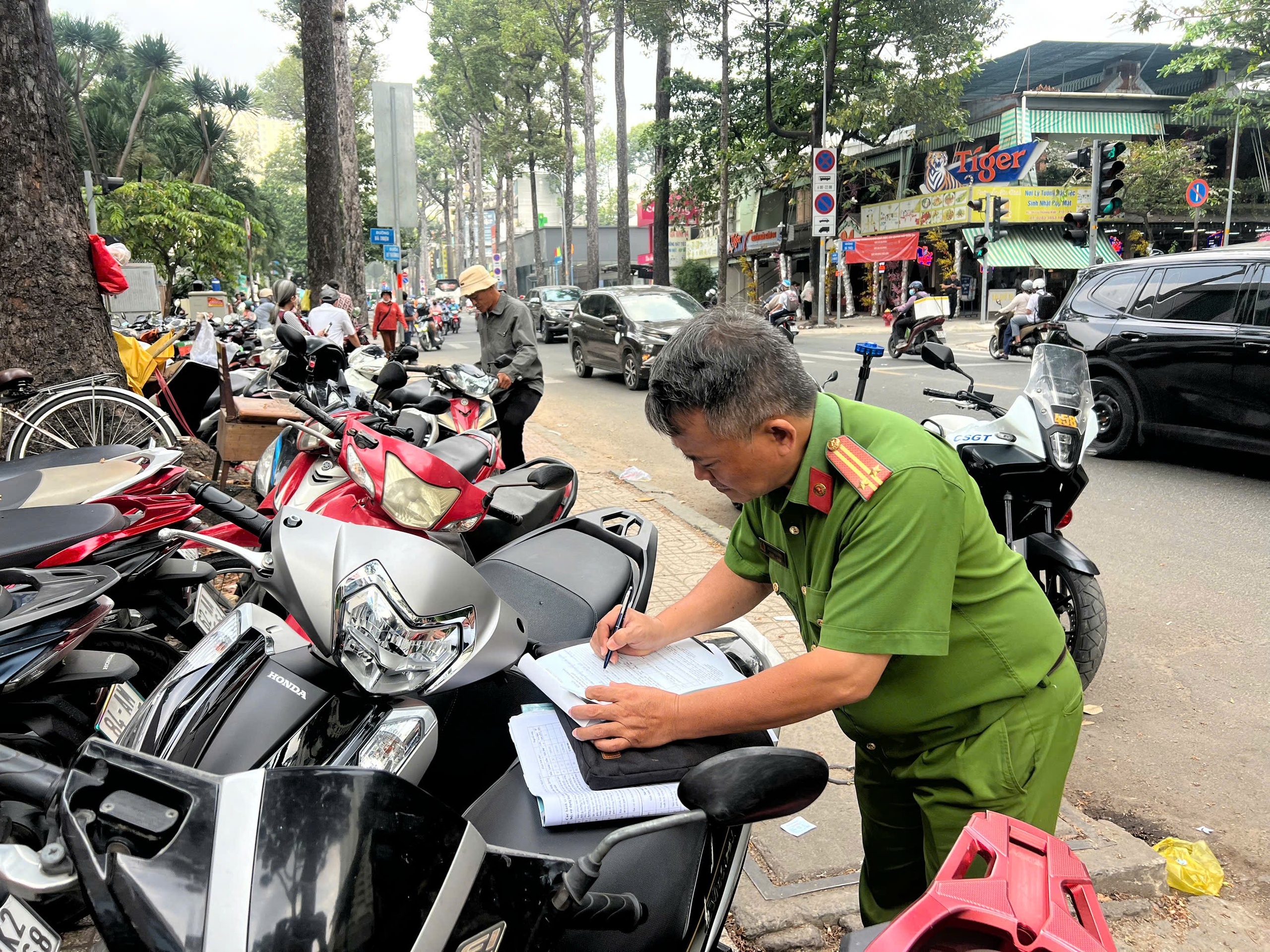 Công an TP.HCM xử lý tình trạng 'xẻ thịt' vỉa hè, thu phí giữ xe trái phép - Ảnh 3.