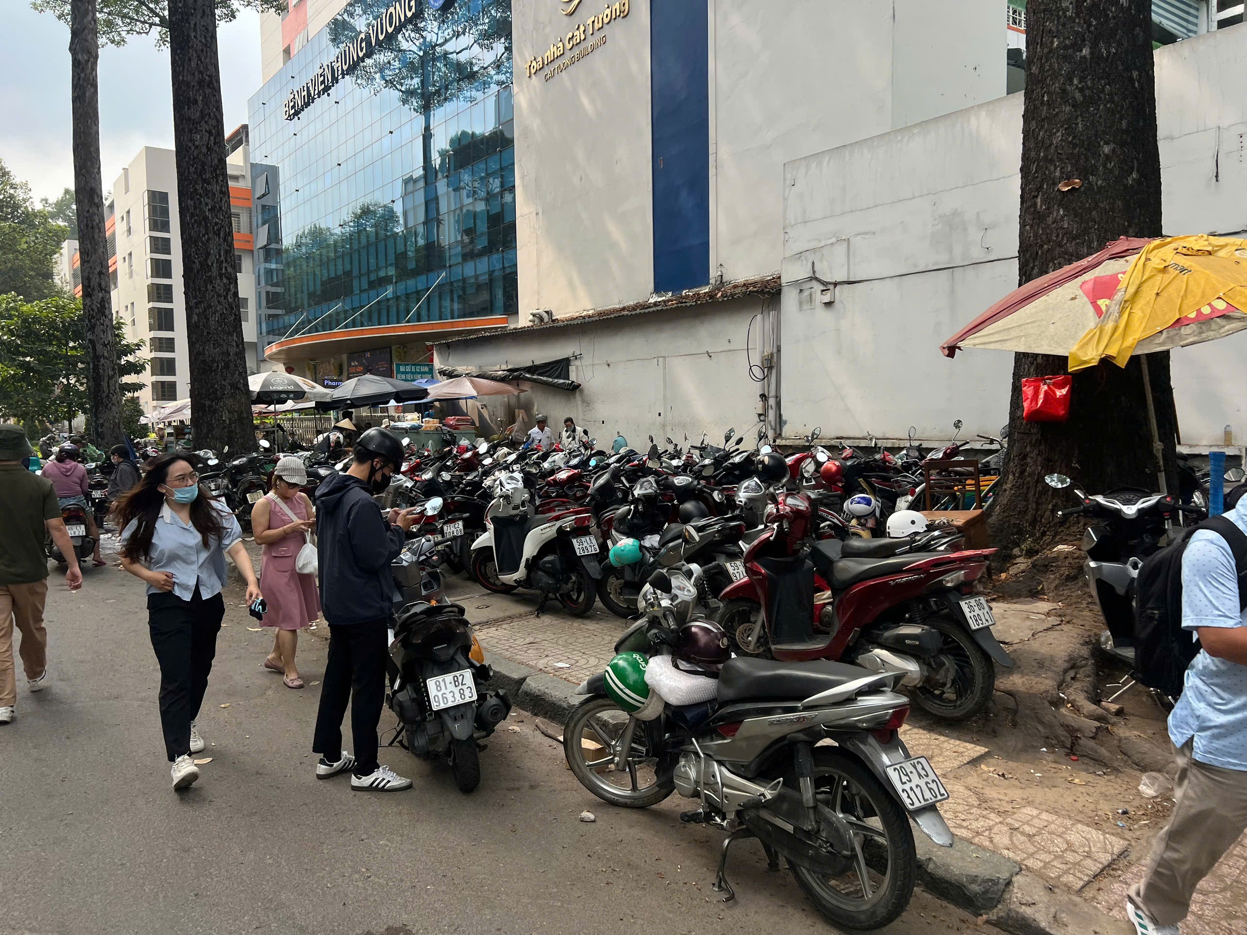 Công an TP.HCM xử lý tình trạng 'xẻ thịt' vỉa hè, thu phí giữ xe trái phép - Ảnh 1.