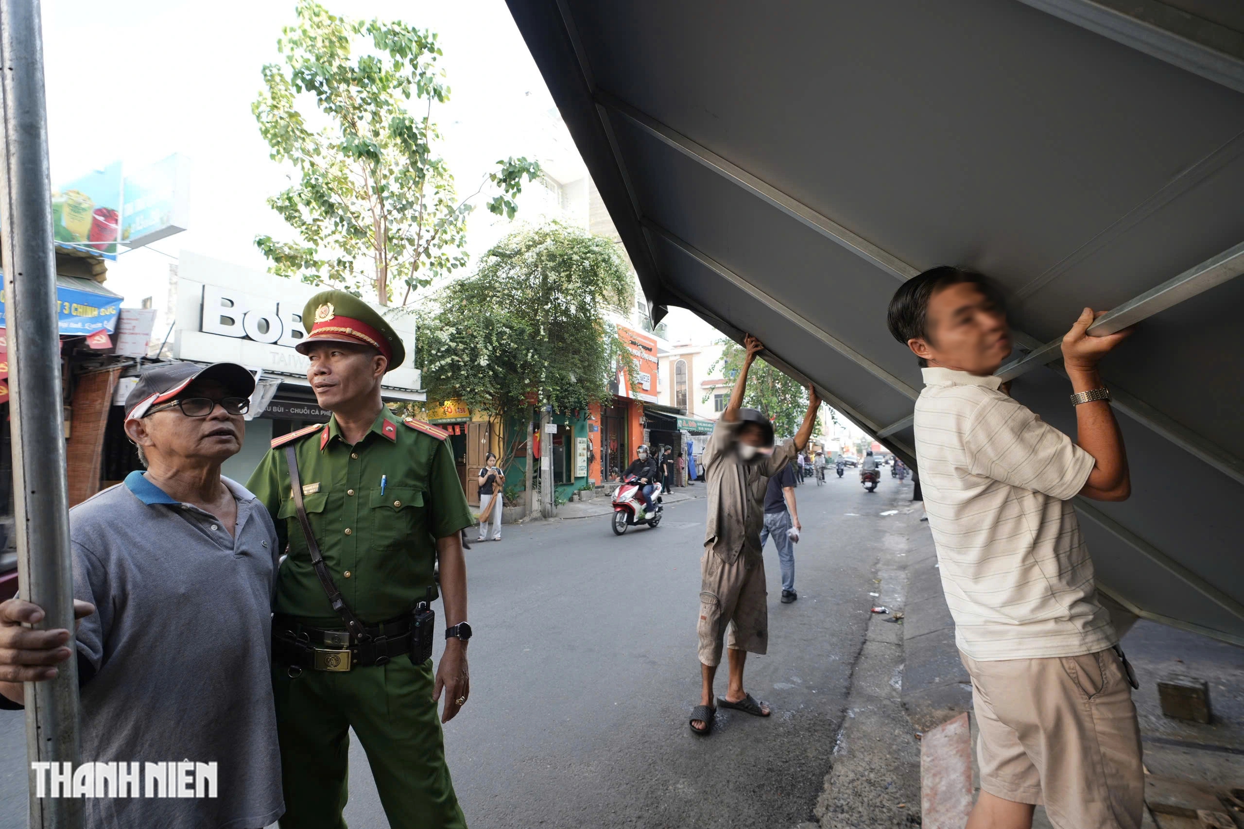 TP.HCM xử lý lấn chiếm vỉa hè: Người dân cất gọn biển hiệu, đường thông thoáng - Ảnh 2.