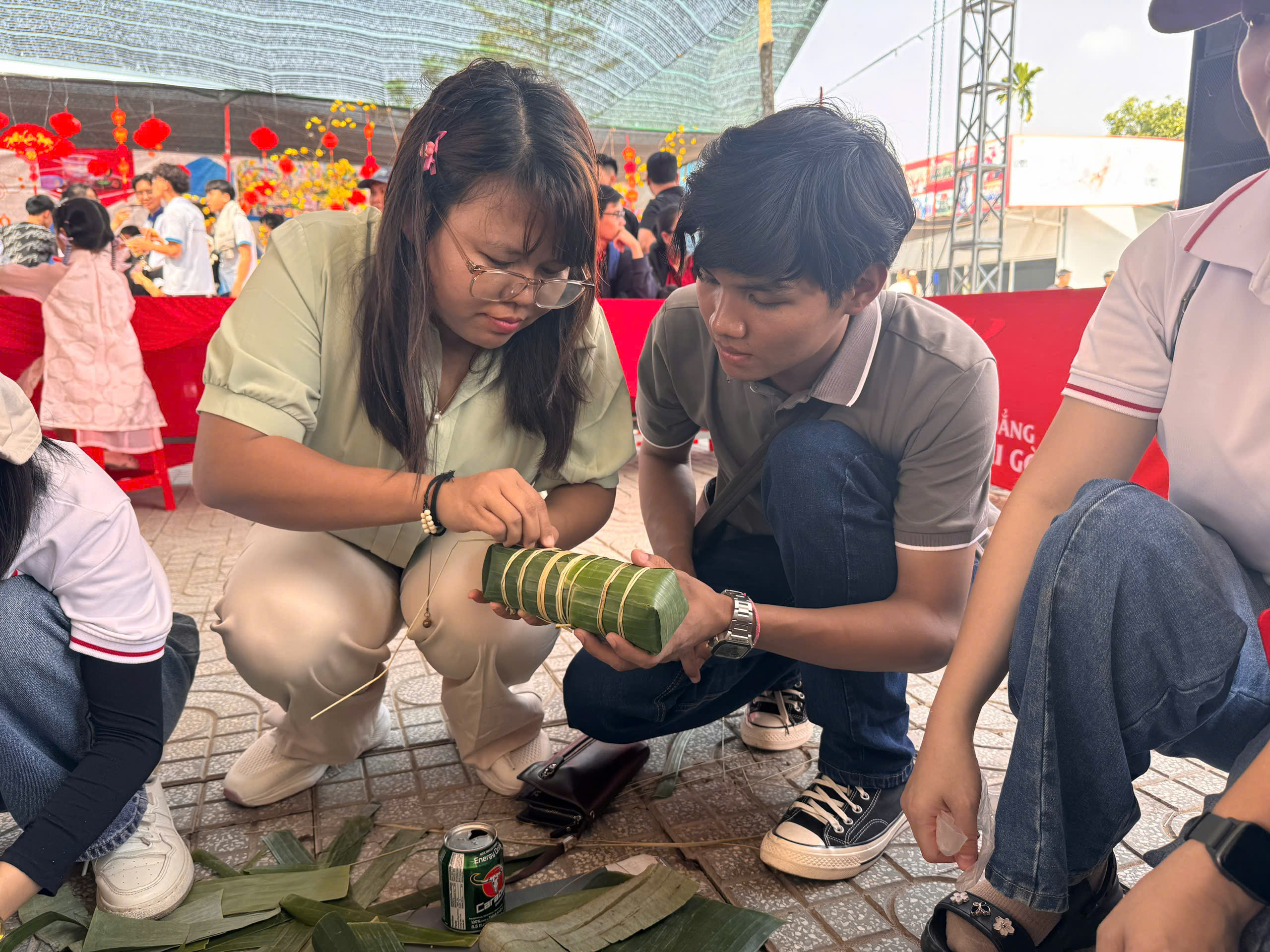 Sinh viên quốc tế lúng túng lần đầu gói bánh tét, đón Tết Việt giữa giảng đường - Ảnh 4.