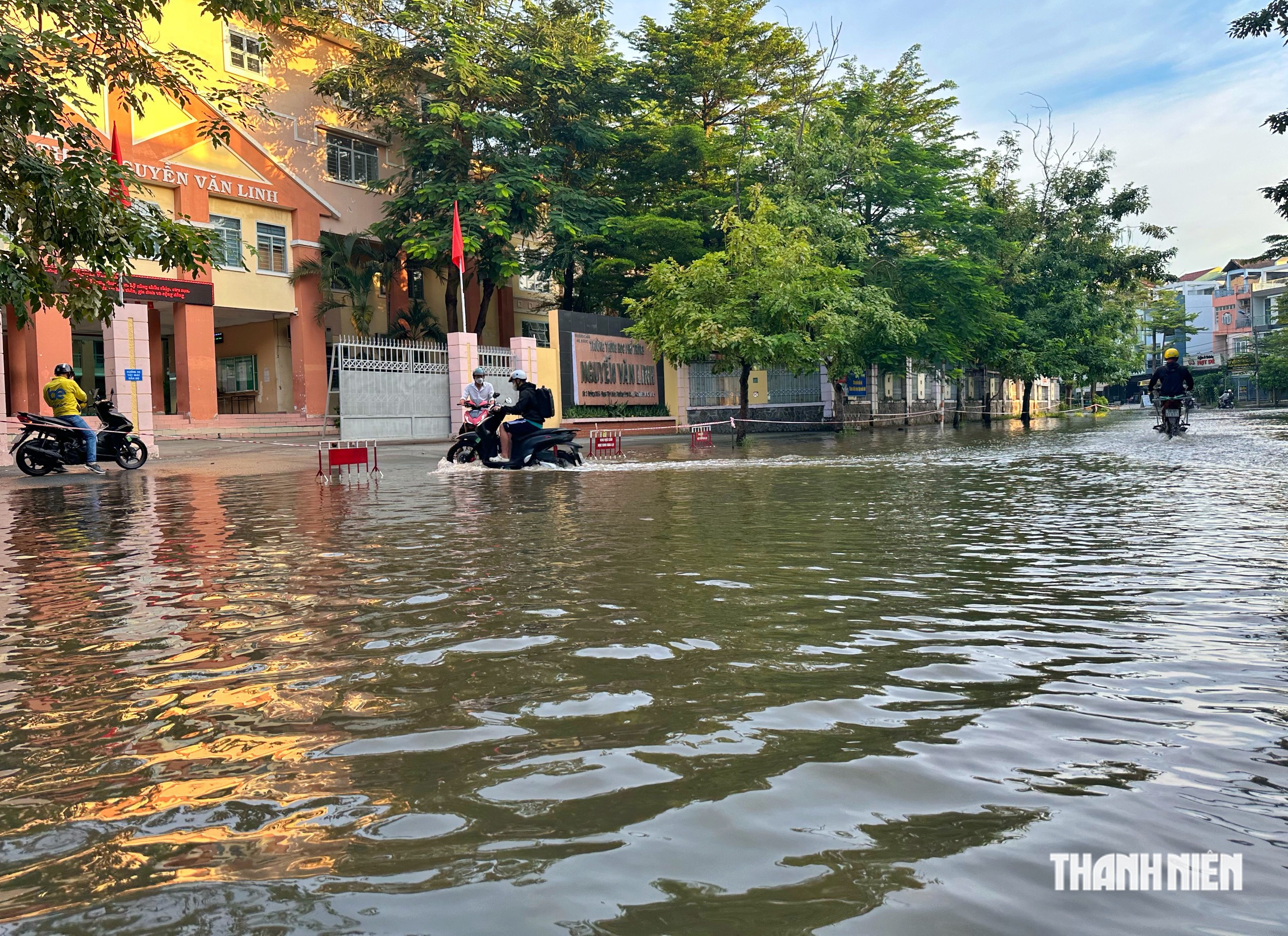 Triều cường sáng 27.10 ở TP.HCM: Người vượt đường ngập đi làm, người mang chài bắt cá- Ảnh 1.