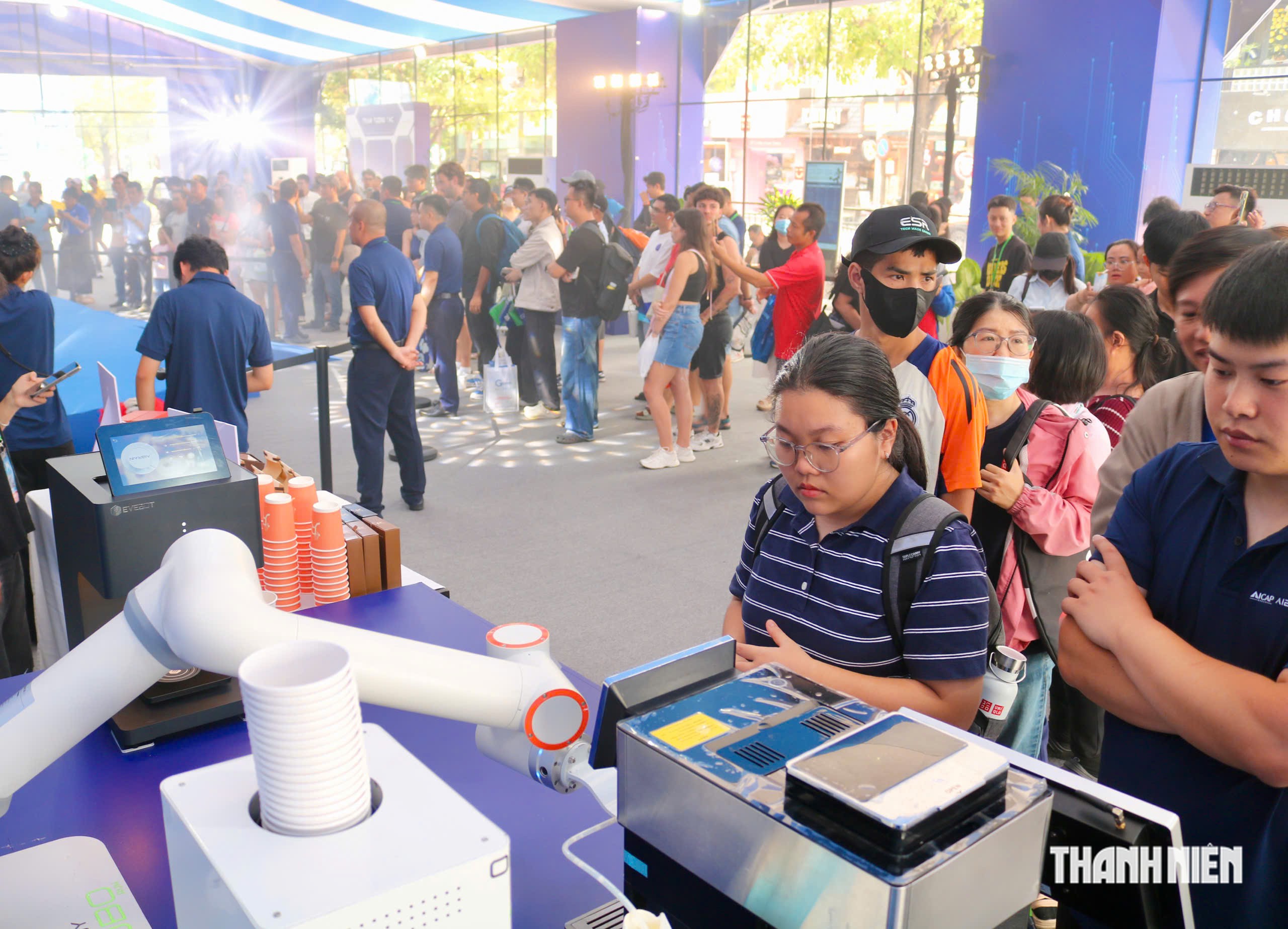 Nhiều người xếp h&agrave;ng d&agrave;i đợi thưởng thức c&agrave; ph&ecirc; miễn ph&iacute; do robot pha chế - Ảnh 1.