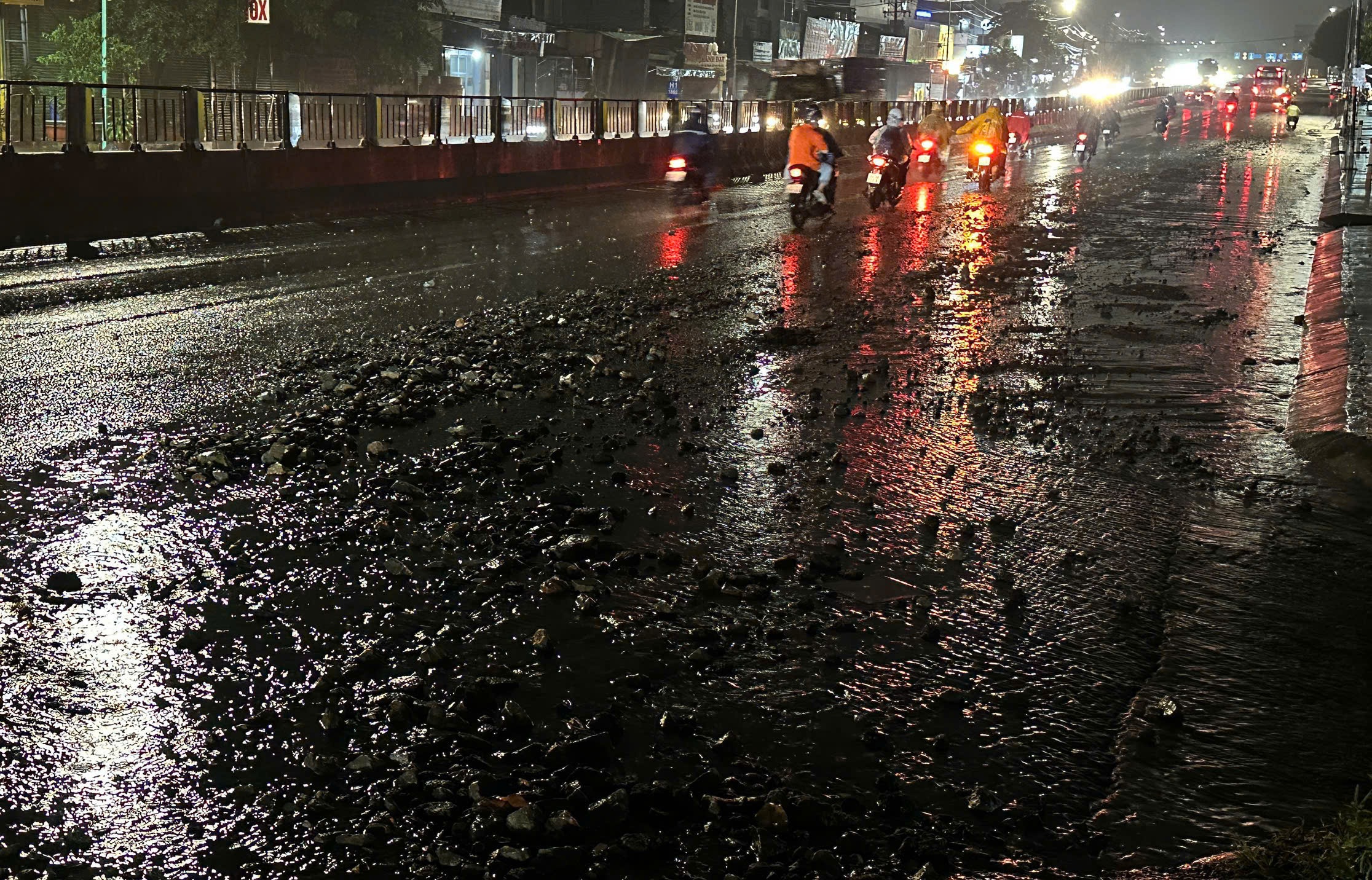 Mặt đường quốc lộ 1 đá lổm chổm sau cơn mưa lớn, nhiều xe máy té ngã- Ảnh 2.
