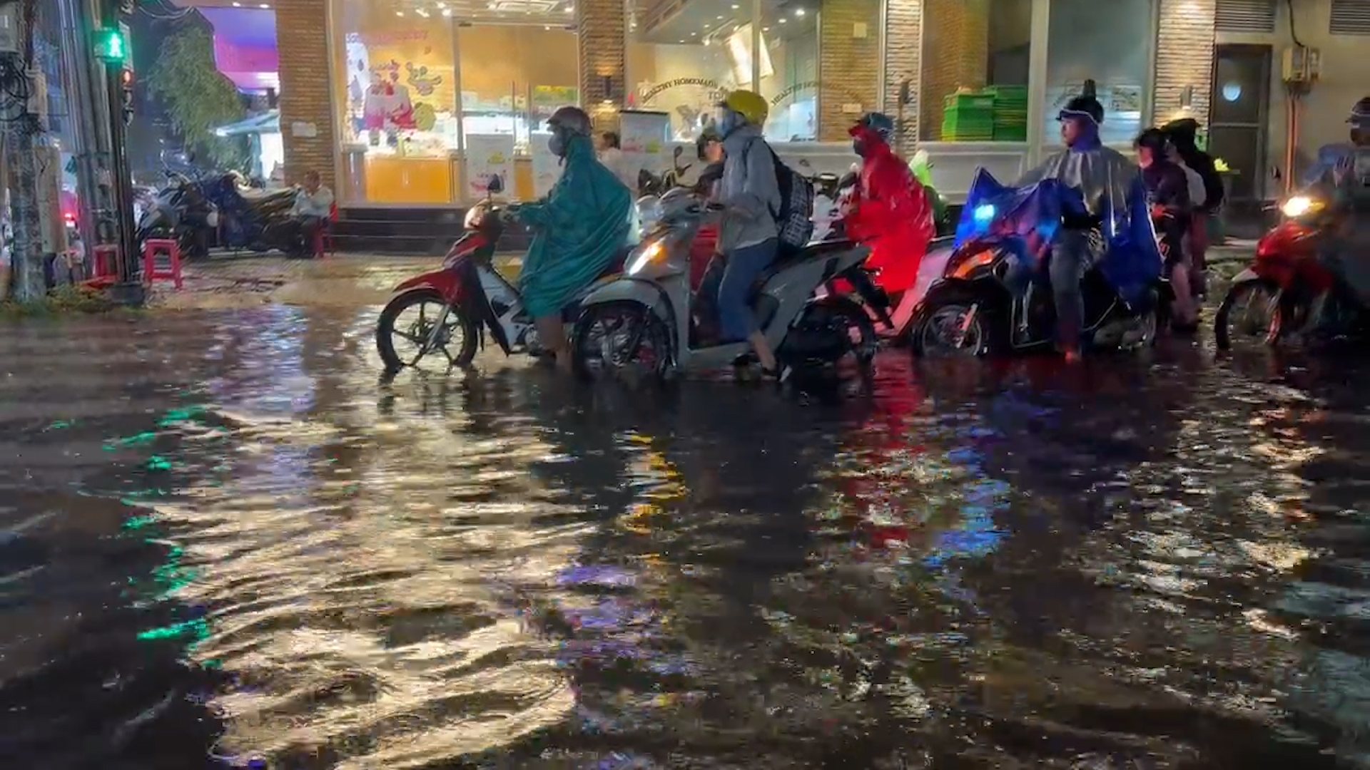 Mưa lớn giờ cao điểm ở TP.HCM: Đi một đoạn lại dừng đèn đỏ, ngâm chân giữa nước ngập - Ảnh 1.