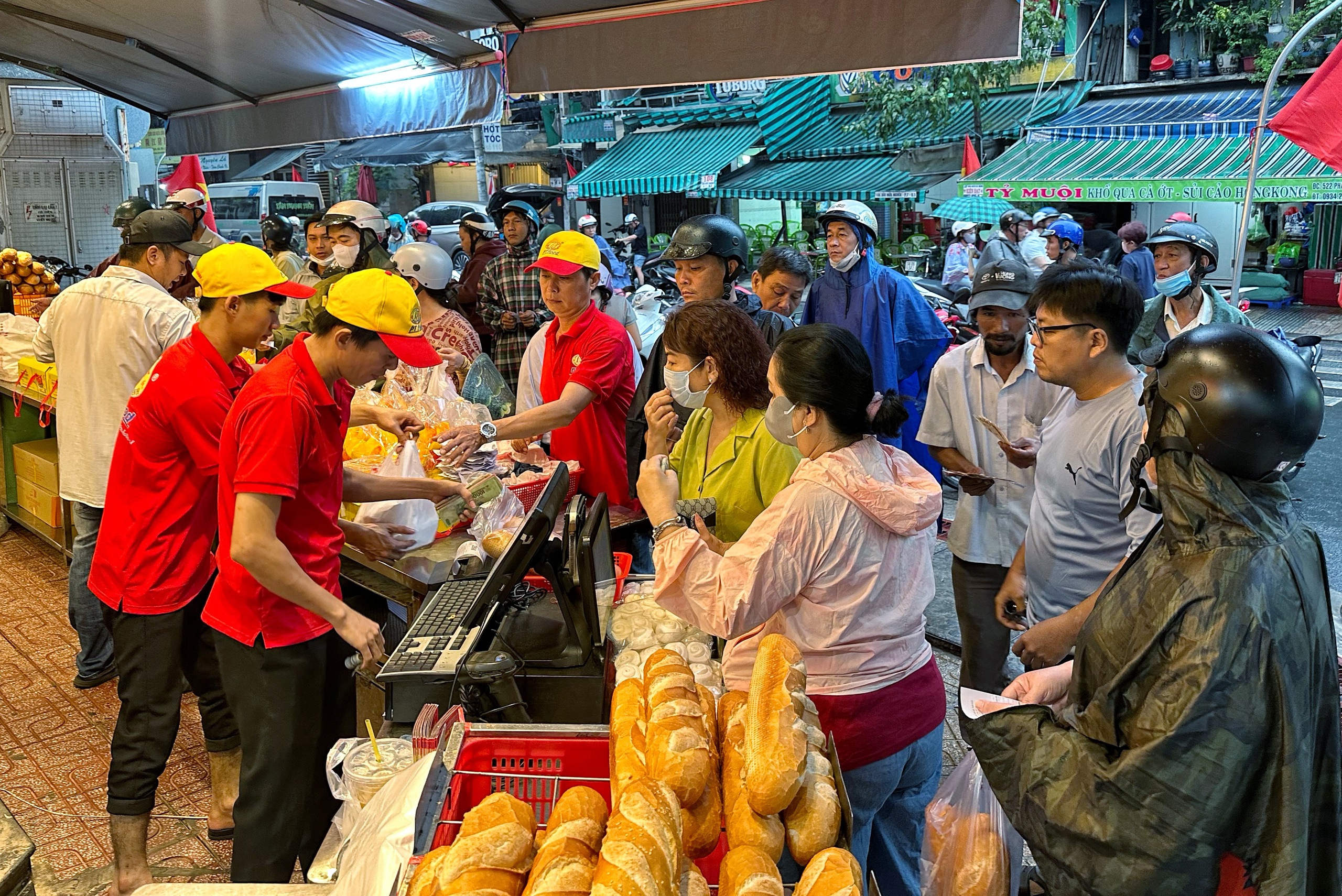 Sáng nay hàng dài người dân TP.HCM đội mưa mua vịt quay, heo quay ngày Thần tài - Ảnh 8.