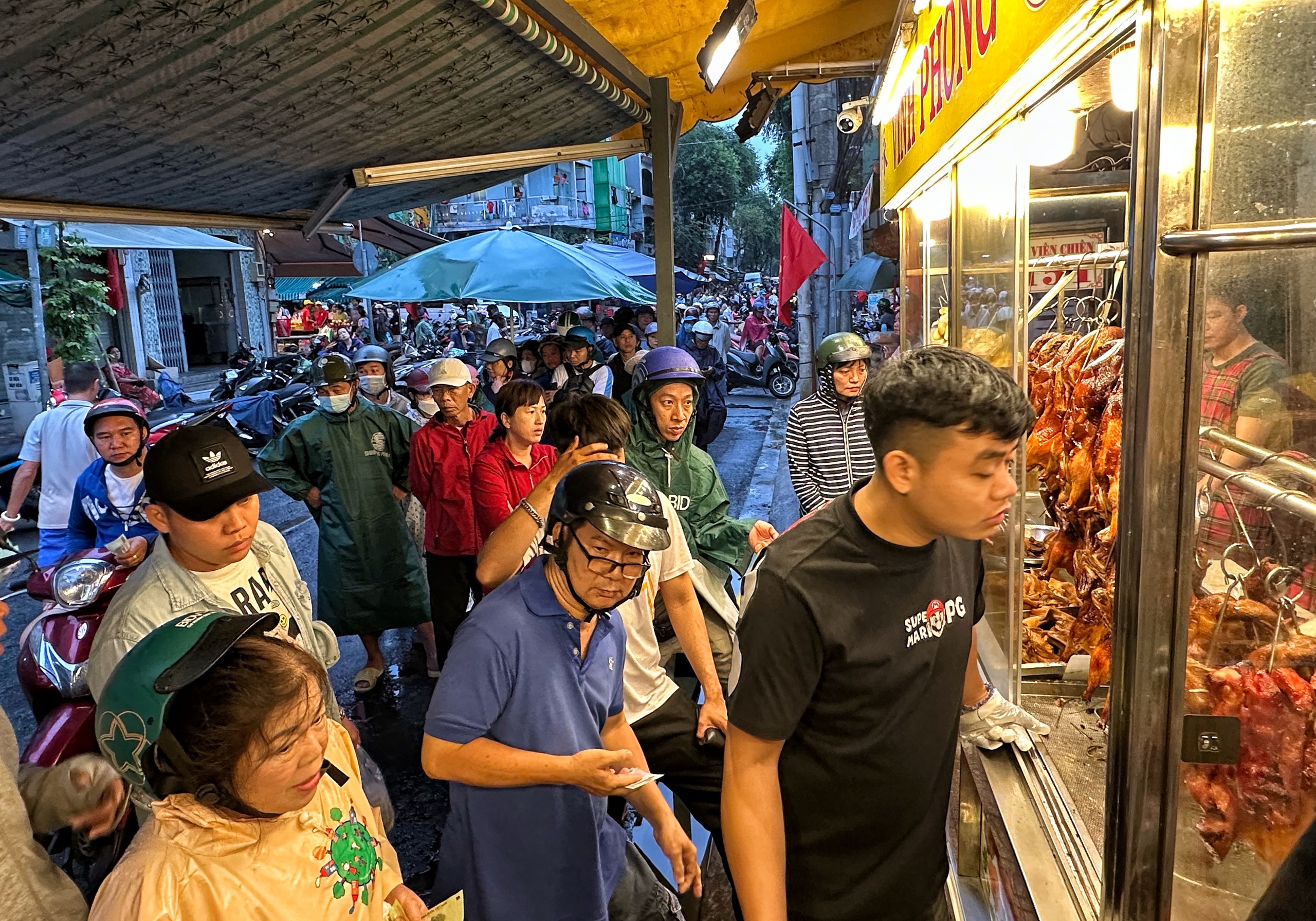 Sáng nay hàng dài người dân TP.HCM đội mưa mua vịt quay, heo quay ngày Thần tài - Ảnh 3.