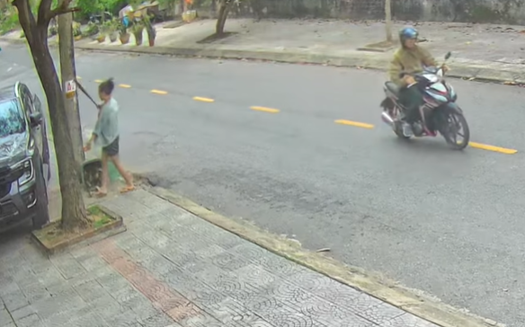 Người phụ nữ dùng gậy đập phá ô tô đậu ven đường - Ảnh 1.