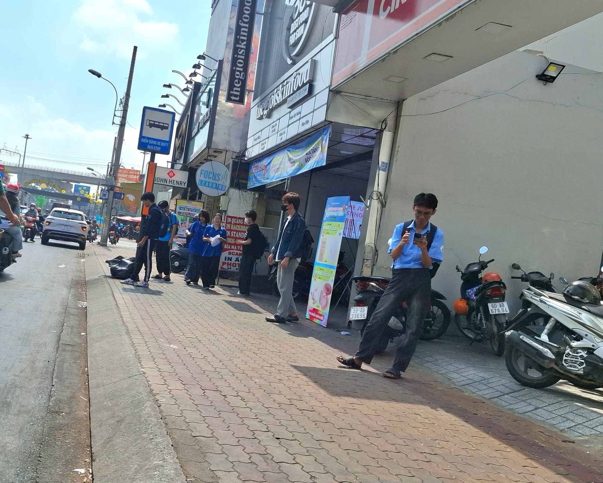 Hành khách phải đứng ngoài nắng chờ xe buýt- Ảnh 1. Hành khách phải đứng ngoài nắng chờ xe buýt- Ảnh 1.