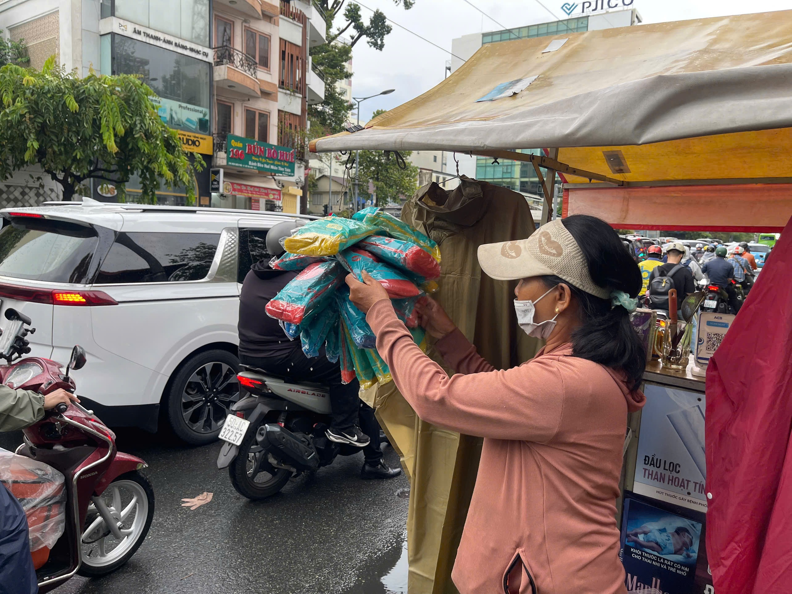  Nhiều hàng rong TP.HCM bán thêm áo mưa kiếm thu nhập  - Ảnh 2.