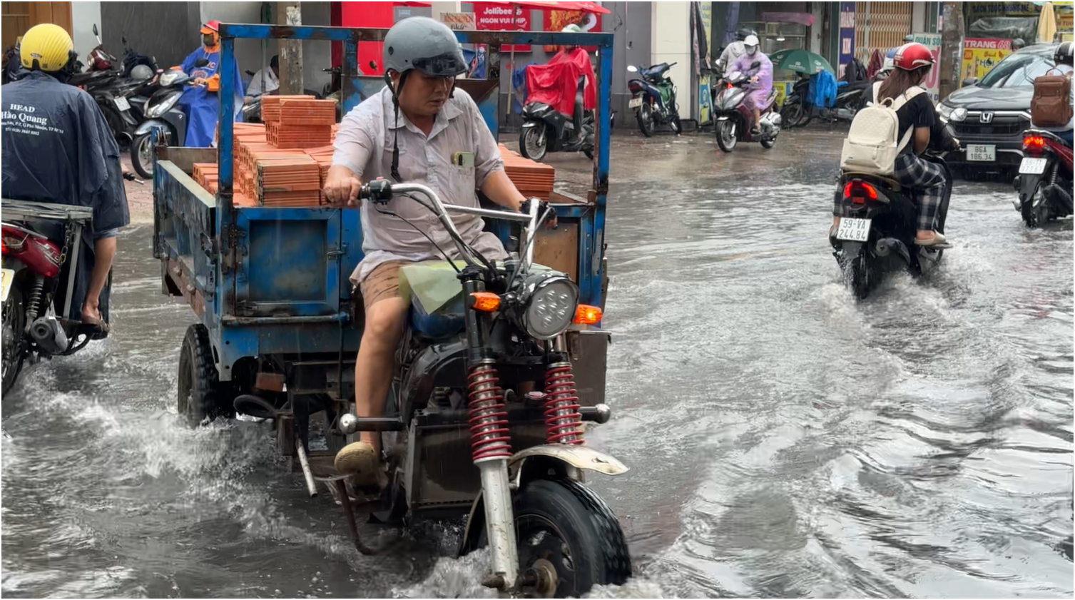 Mưa lớn kéo dài cả ngày ở TP.HCM, người dân ám ảnh cảnh ‘lội nước dơ’ - Ảnh 1.