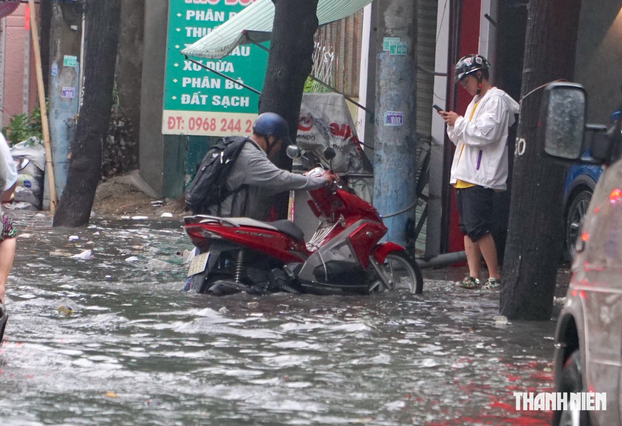 Nhiều tuyến đường lại ngập, người d&acirc;n vất vả dọn dẹp sau cơn mưa lớn ở TP.HCM - Ảnh 4.