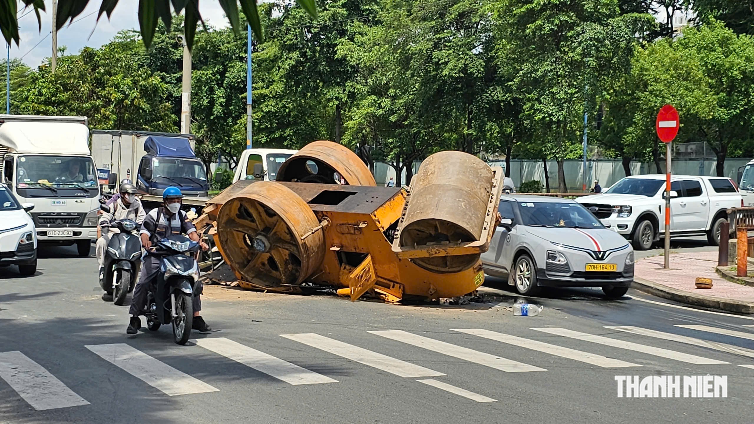 TP.HCM: Xe tải chở xe lu bị lật trên đường, 2 người thoát nạn trong gang tấc- Ảnh 2.