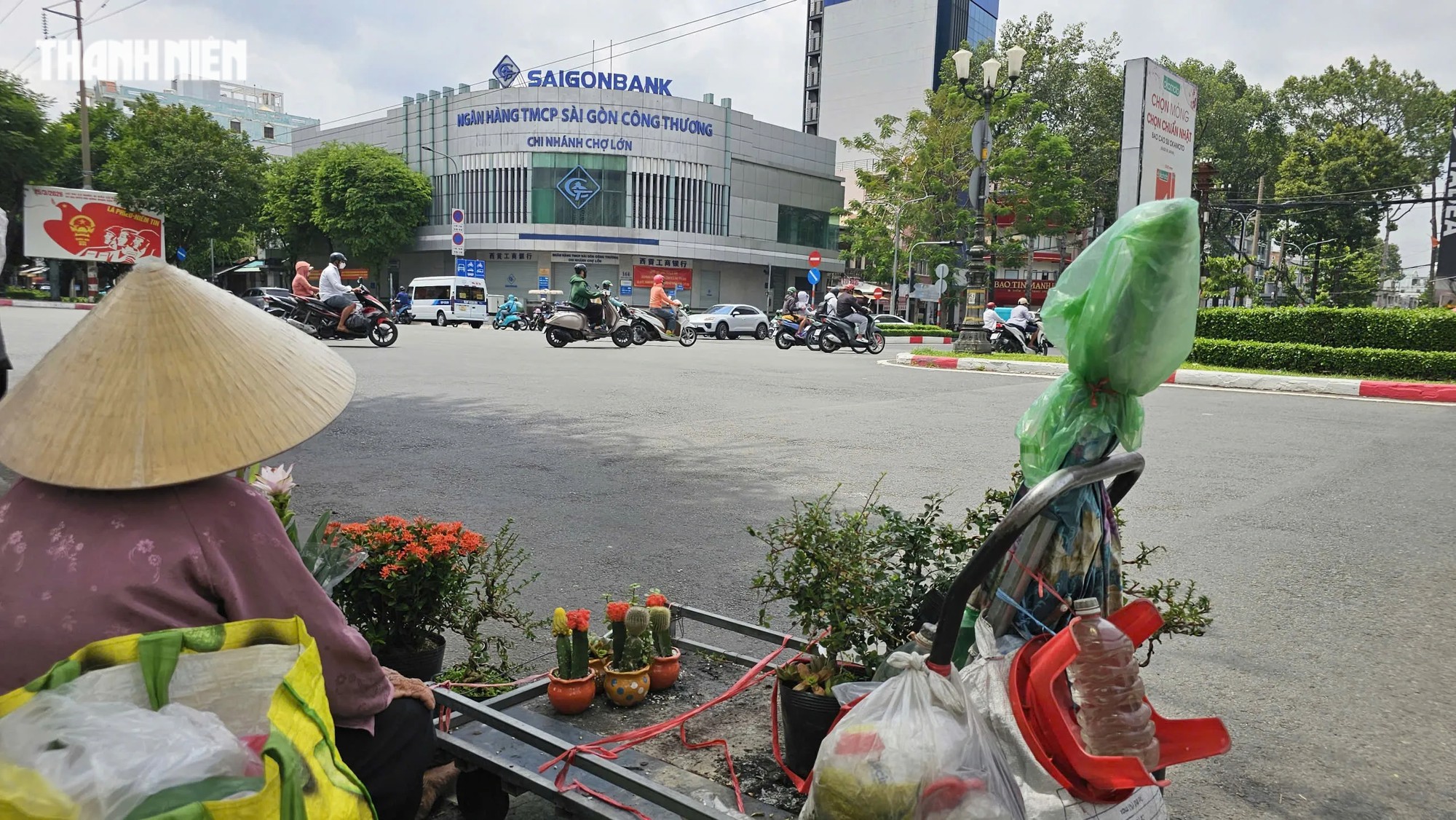 Cụ bà 82 tuổi đẩy xe hoa cảnh mưu sinh giữa nắng gắt TP.HCM - Ảnh 1.