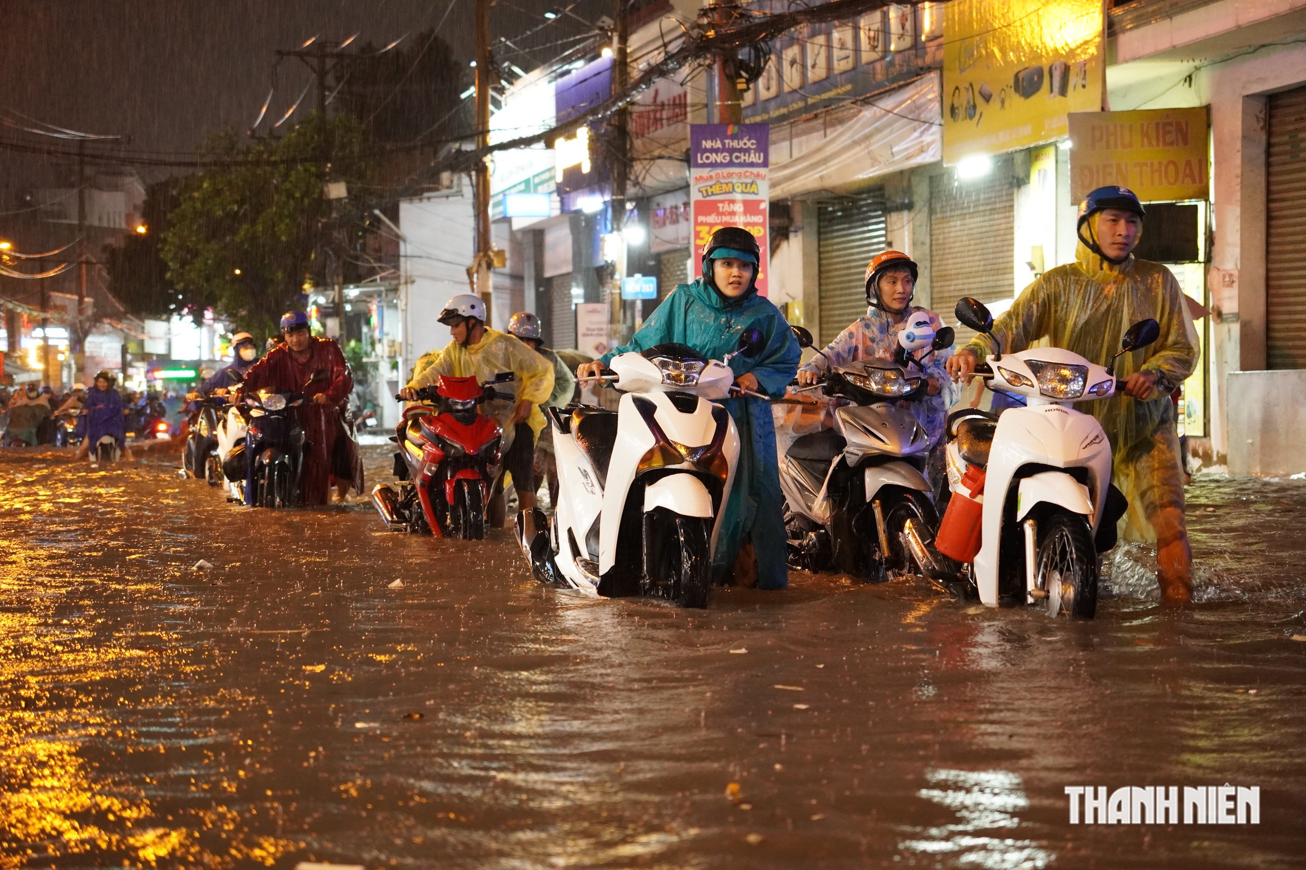 Mưa lớn, h&agrave;ng d&agrave;i người d&acirc;n b&igrave; b&otilde;m dắt xe qua đoạn ngập tại TP.HCM  - Ảnh 1.