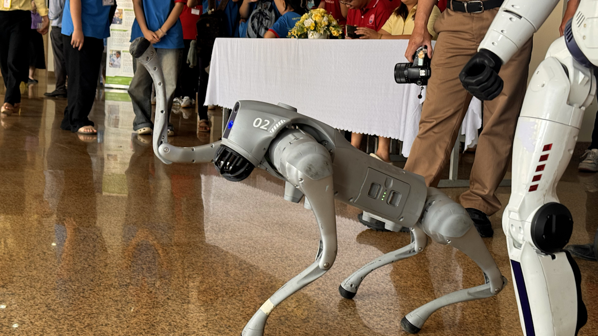 Thích thú xem robot chó Unitree bắt tay, robot hình người vẫy chào, ôm sinh viên - Ảnh 1.