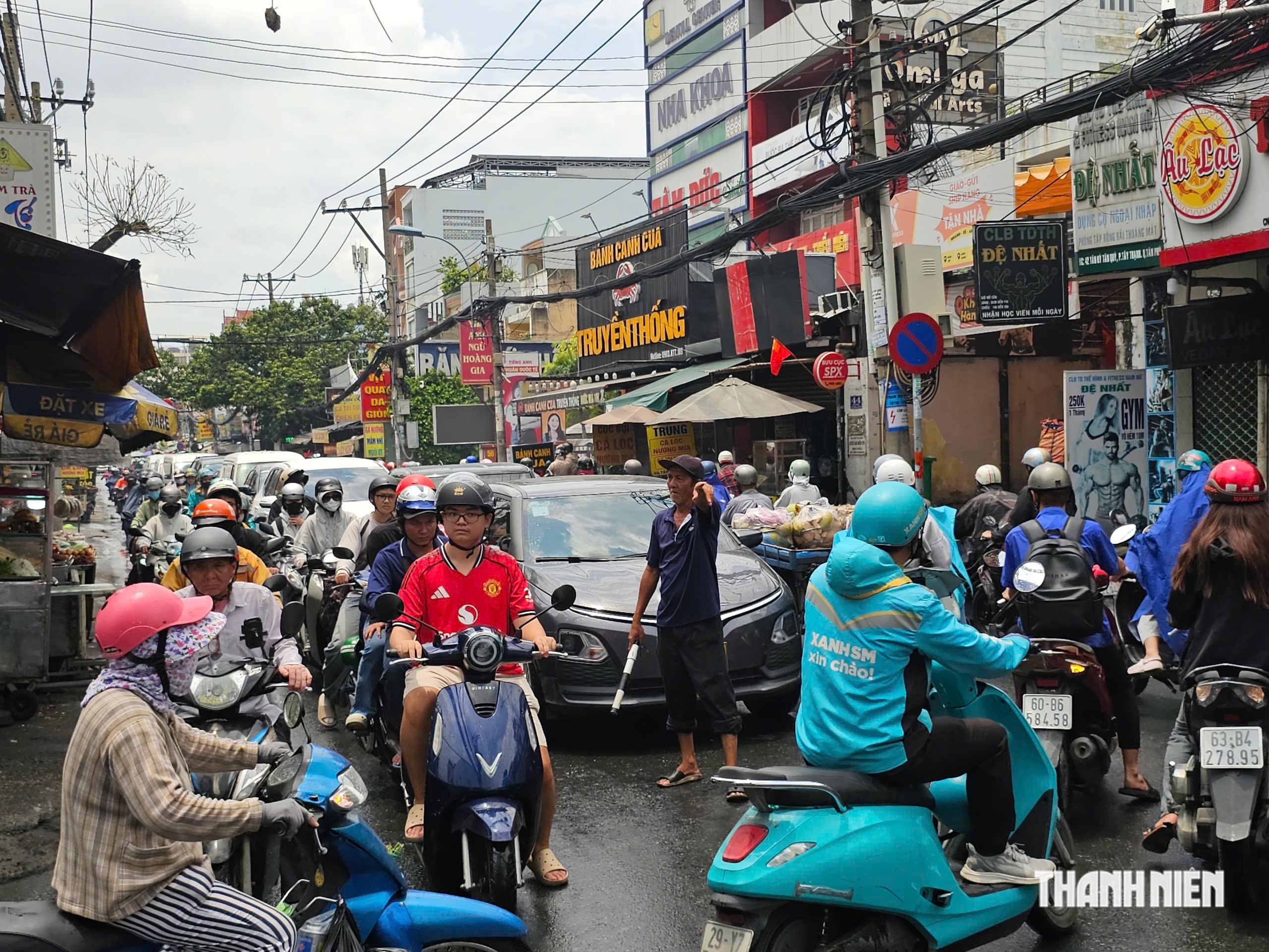 Người đàn ông đội nắng mưa điều tiết giao thông 'không công' ở TP.HCM - Ảnh 1.
