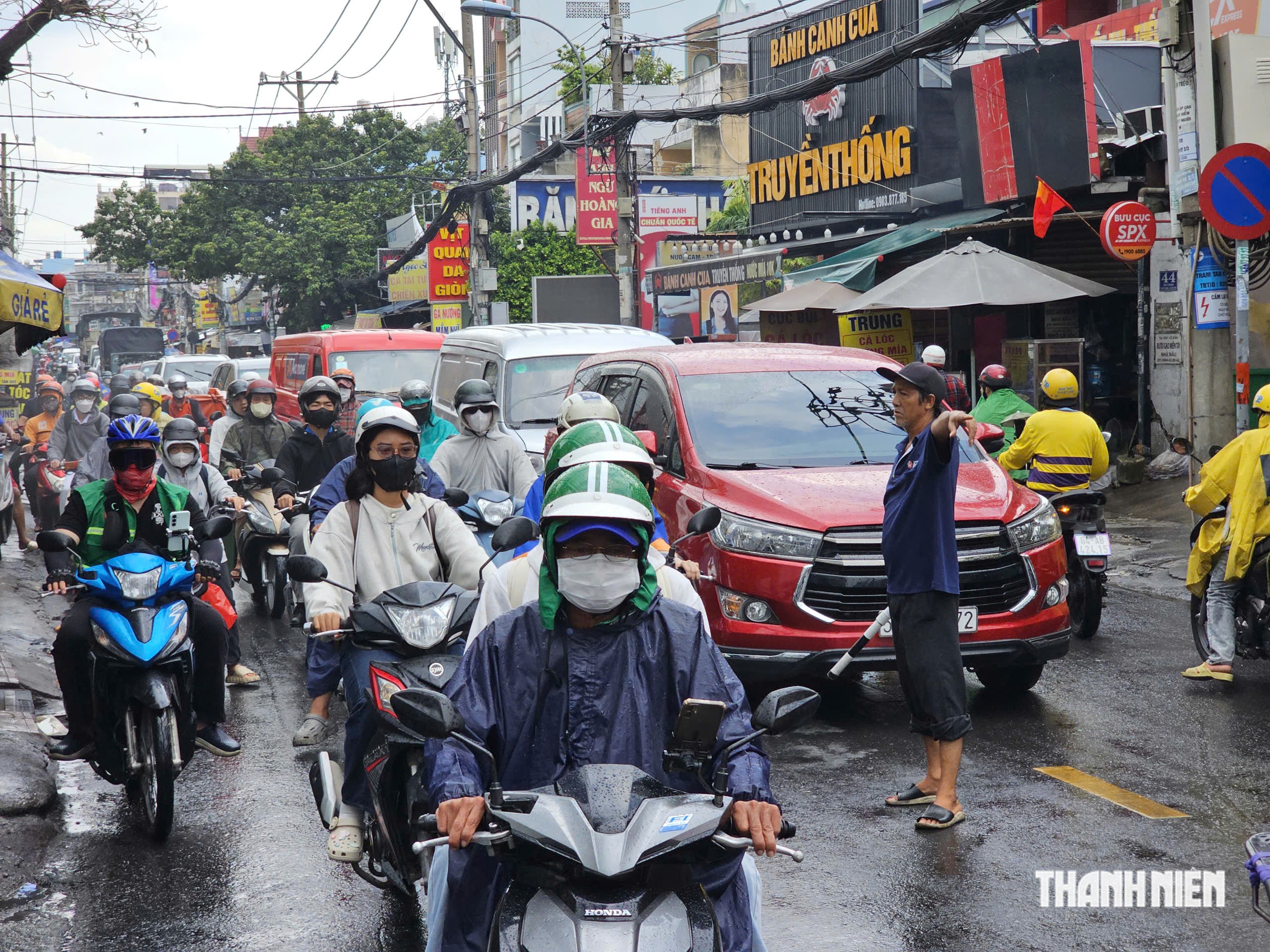 Người đàn ông đội nắng mưa điều tiết giao thông 'không công' ở TP.HCM - Ảnh 2.