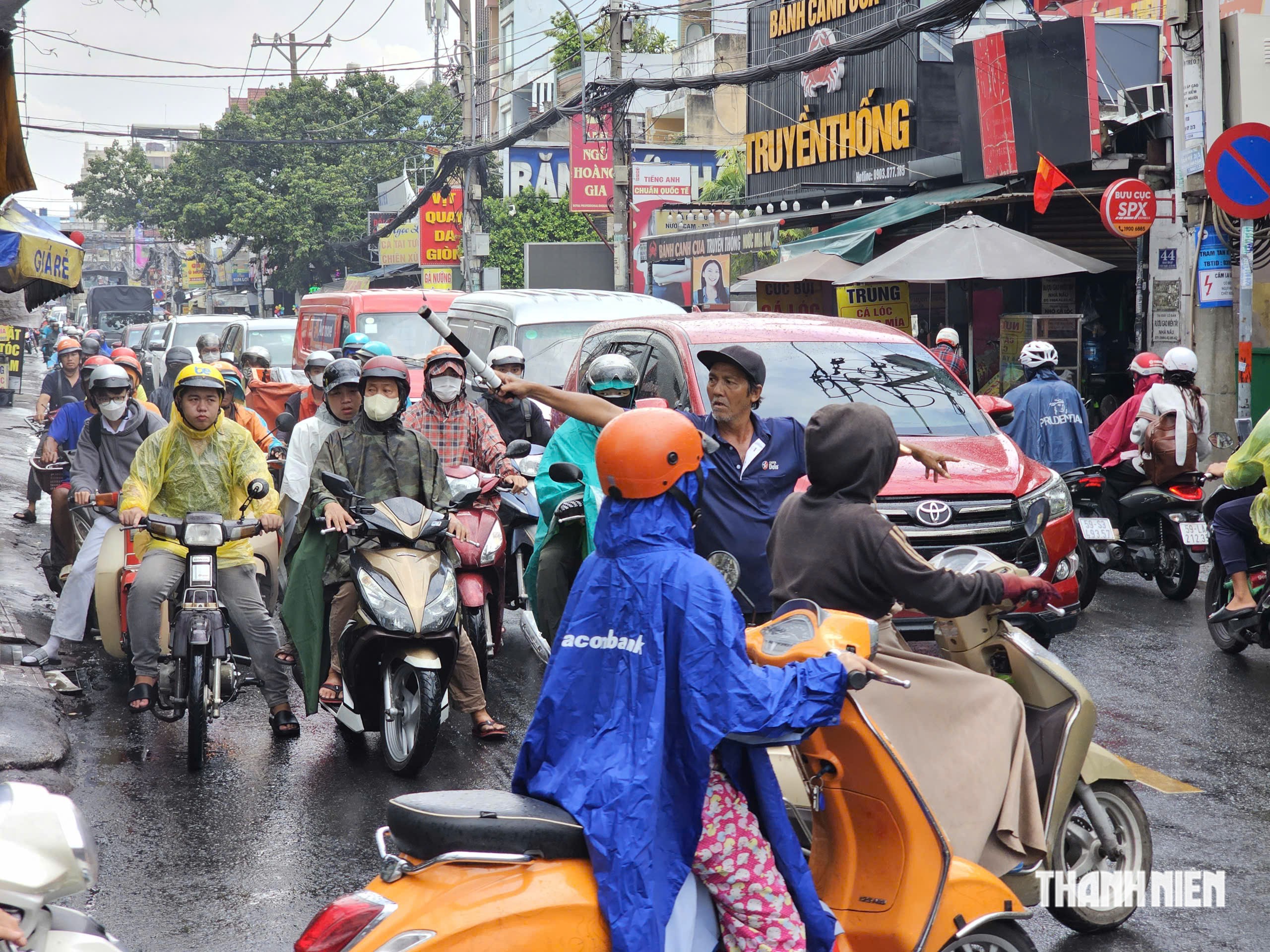 Người đàn ông đội nắng mưa điều tiết giao thông 'không công' ở TP.HCM - Ảnh 4.