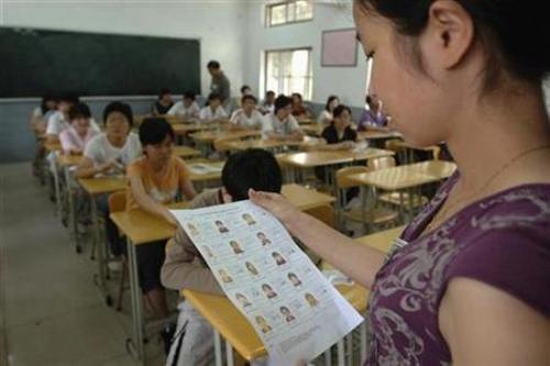 Giám thị điểm danh học sinh trong phòng thi tuyển sinh đại học ở Trung Quốc - Ảnh: Reuters