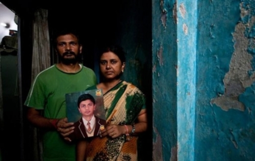 Cha mẹ cầm ảnh cậu bé Shivam Singh bị mất tích cách đây ba tháng - Ảnh: AFP