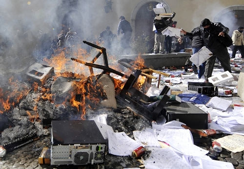 Cảnh sát biểu tình đốt phá tài liệu ở Cơ quan tình báo quốc gia Bolivia - Ảnh: AFP