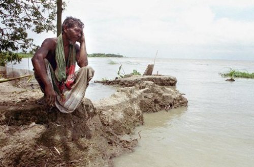 Một người dân Bangladesh ngồi cạnh bờ sông Padma - Ảnh: AFP