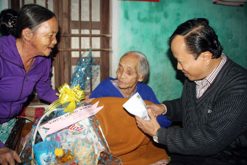 Họa sĩ Đinh Gia Thắng (phải) thăm hỏi và tặng quà cho mẹ Huỳnh Thị Tình ở TP.Tam Kỳ 