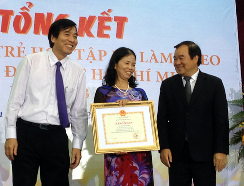 Ông Đào Văn Lừng (trái) và ông Trần Quang Quý (phải) trao giải nhất cá nhân cho giáo viên Nguyễn Thị Hòa