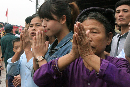 Người dân theo dõi lễ hội và cầu nguyện khi đoàn rước kiệu, thuyền Long Châu đi qua