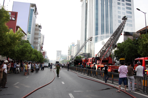 Rất đông người dân đứng bên kia đường theo dõi vụ cháy