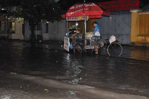 Một người bán ngô vẫn mưu sinh giữa đường nước ngập